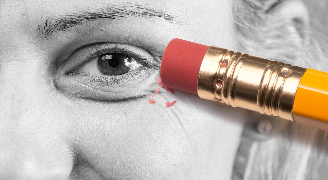 black and white closeup image of woman, pencil erasing, eye