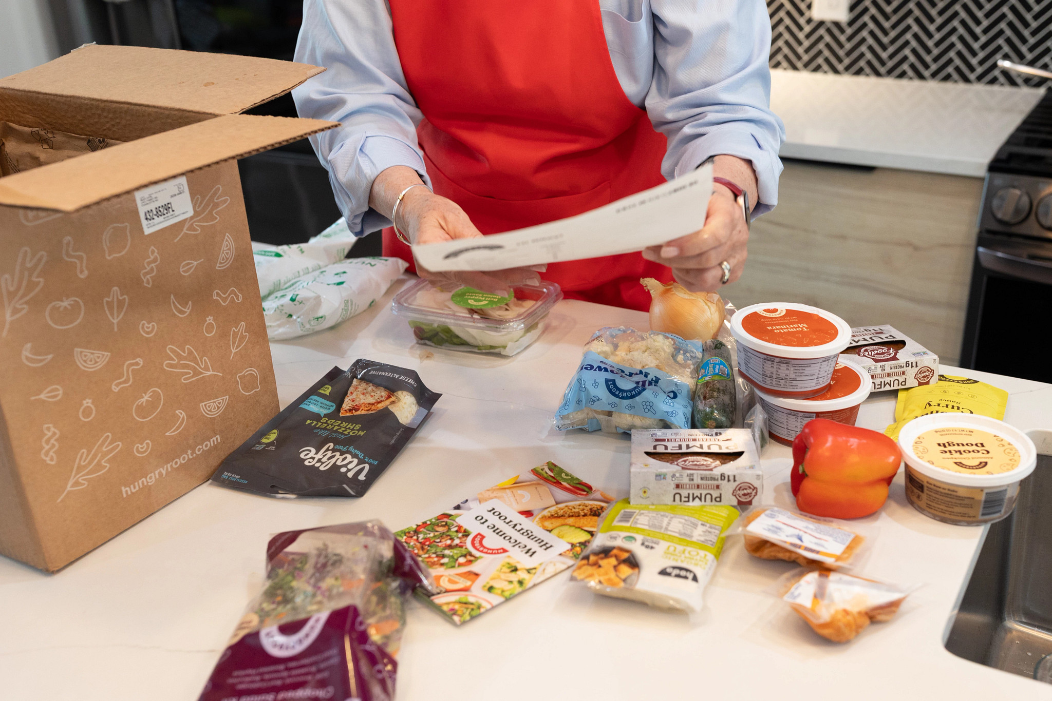 An older adult tester examining the instructions of a Hungryroot meal box.