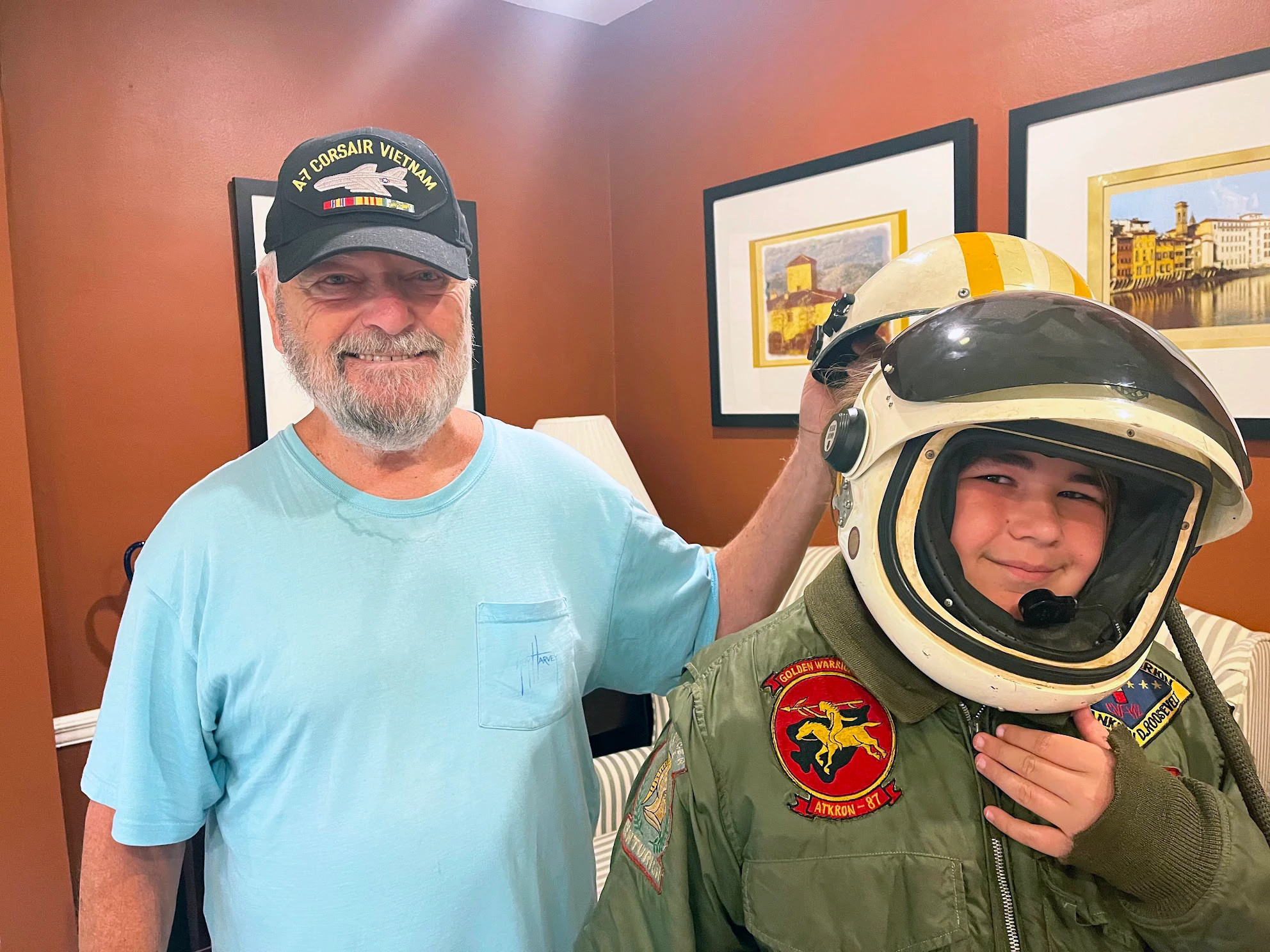 A photo shows Jim Lichtenwalter having fun with his grandson, Charlie, who is trying on his grandfather’s flight gear.