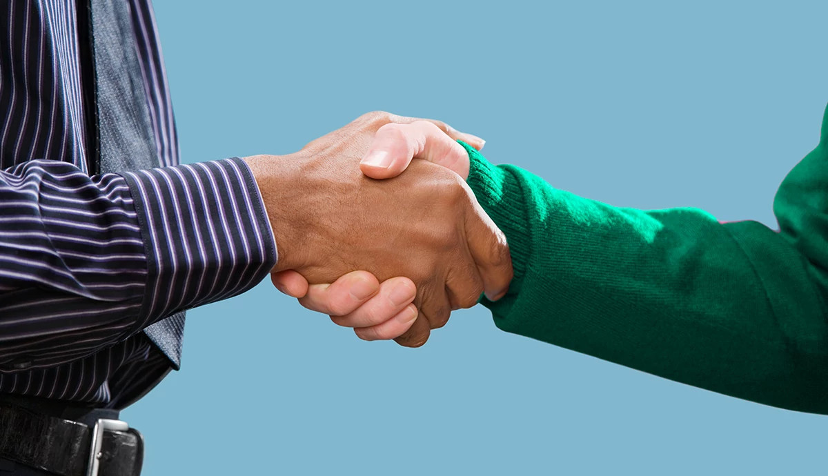 A close up image of two people shaking hands