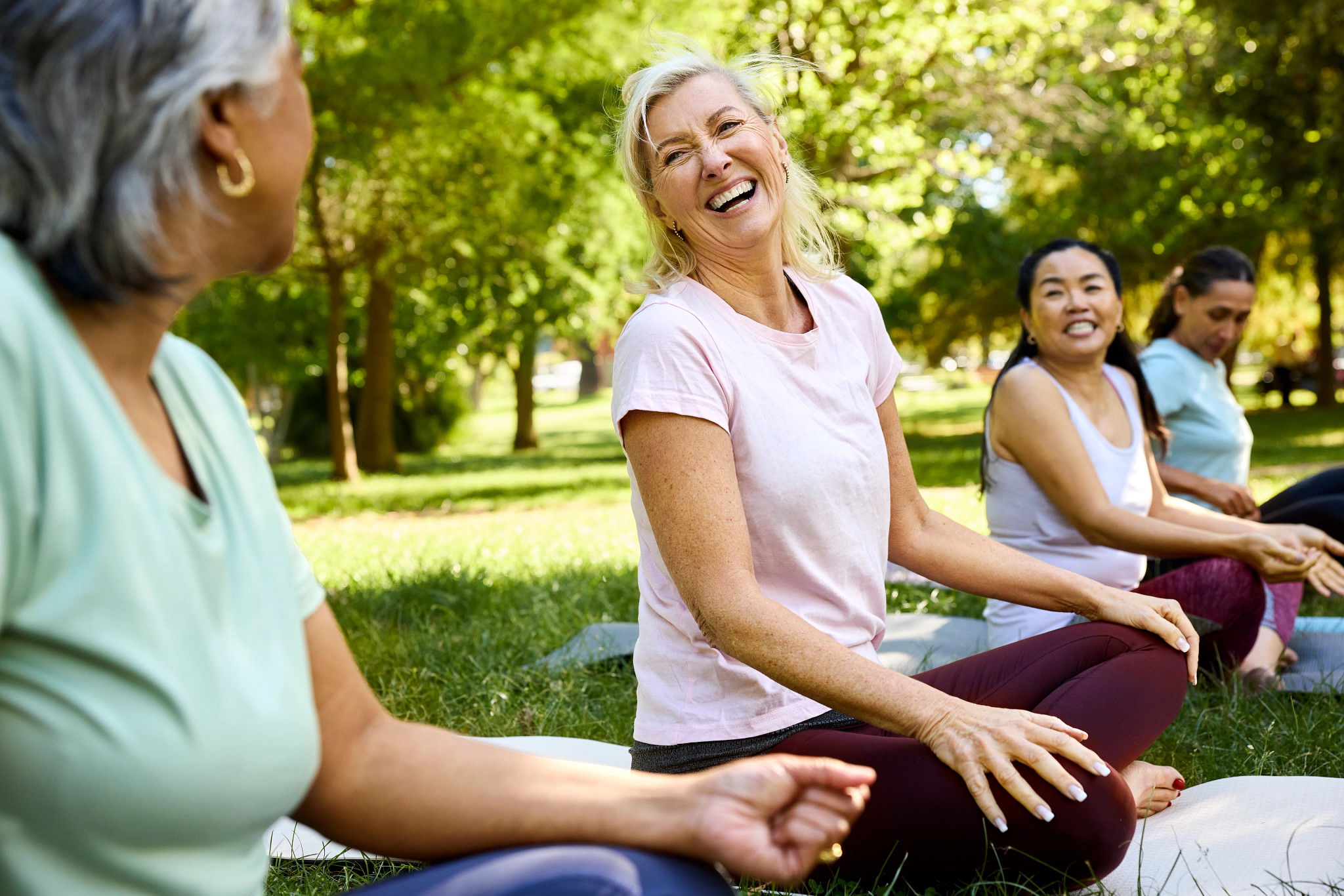 Happy woman sitting for yoga with friends