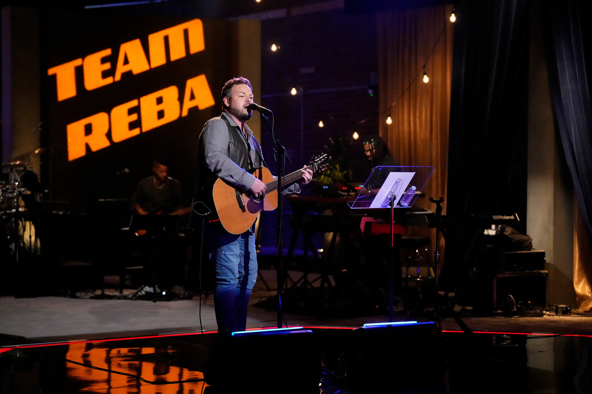 The Voice contestant Josh Sanders performing with an acoustic guitar during the Season 25 The Knockouts Premiere episode