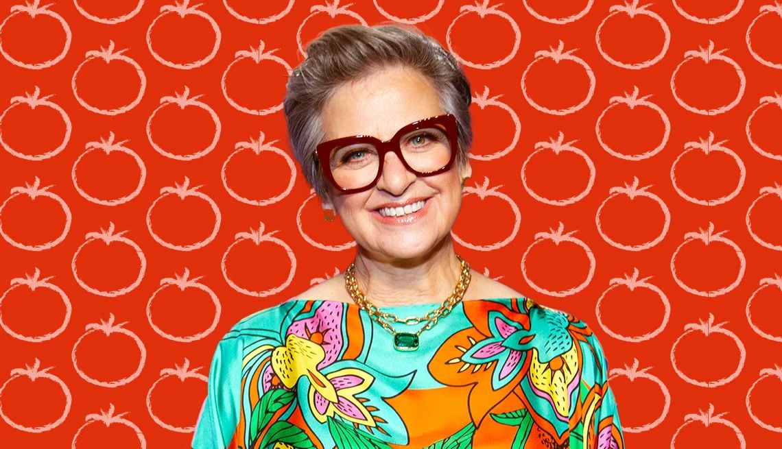 Caroline Manzo Dishes Up Italian American Recipes in ‘Food & Other Things I Love’ Caroline Manzo wearing colorful shirt against orange background with outlines of tomatoes