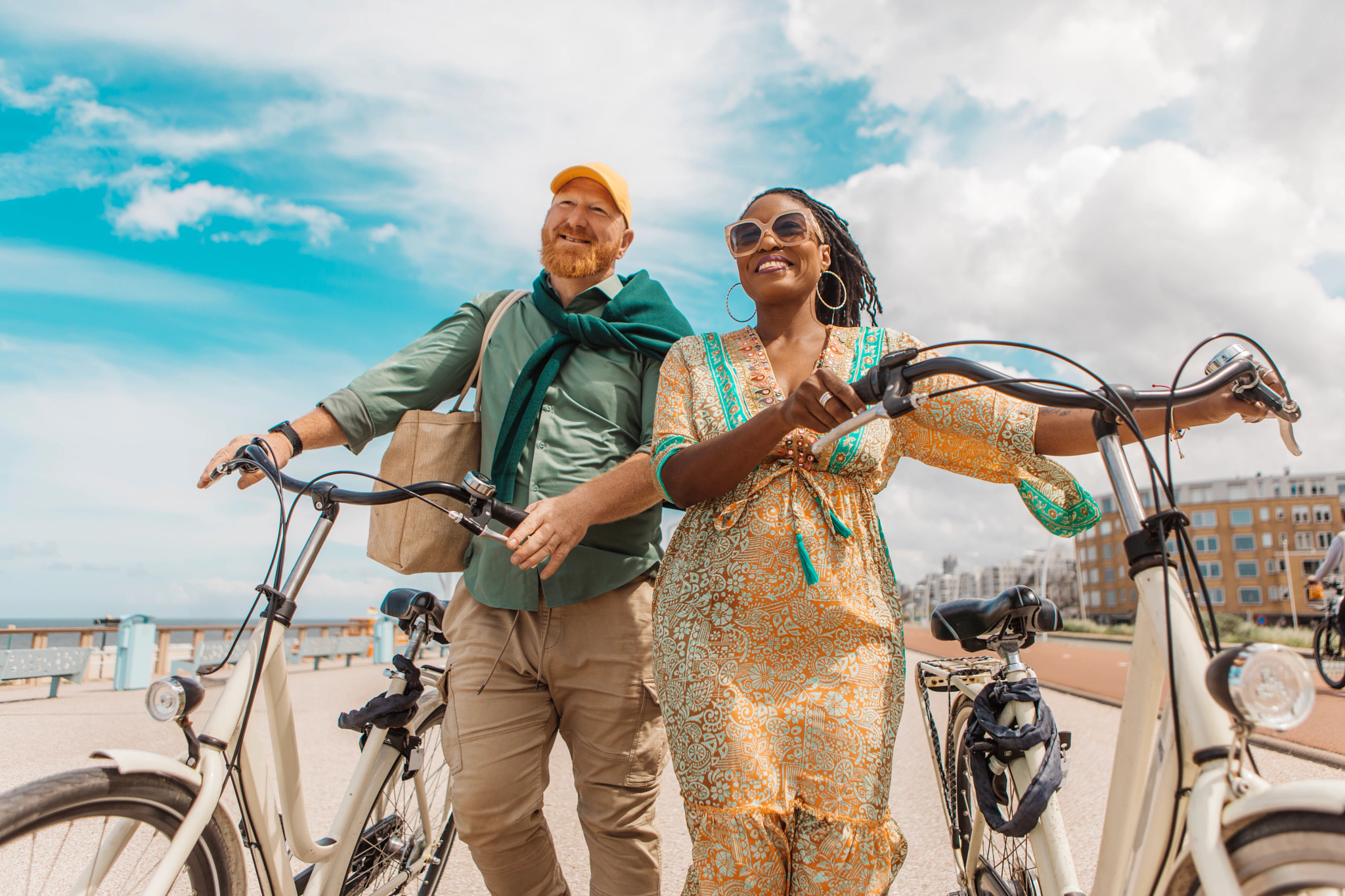 a couple riding bikes along a beach