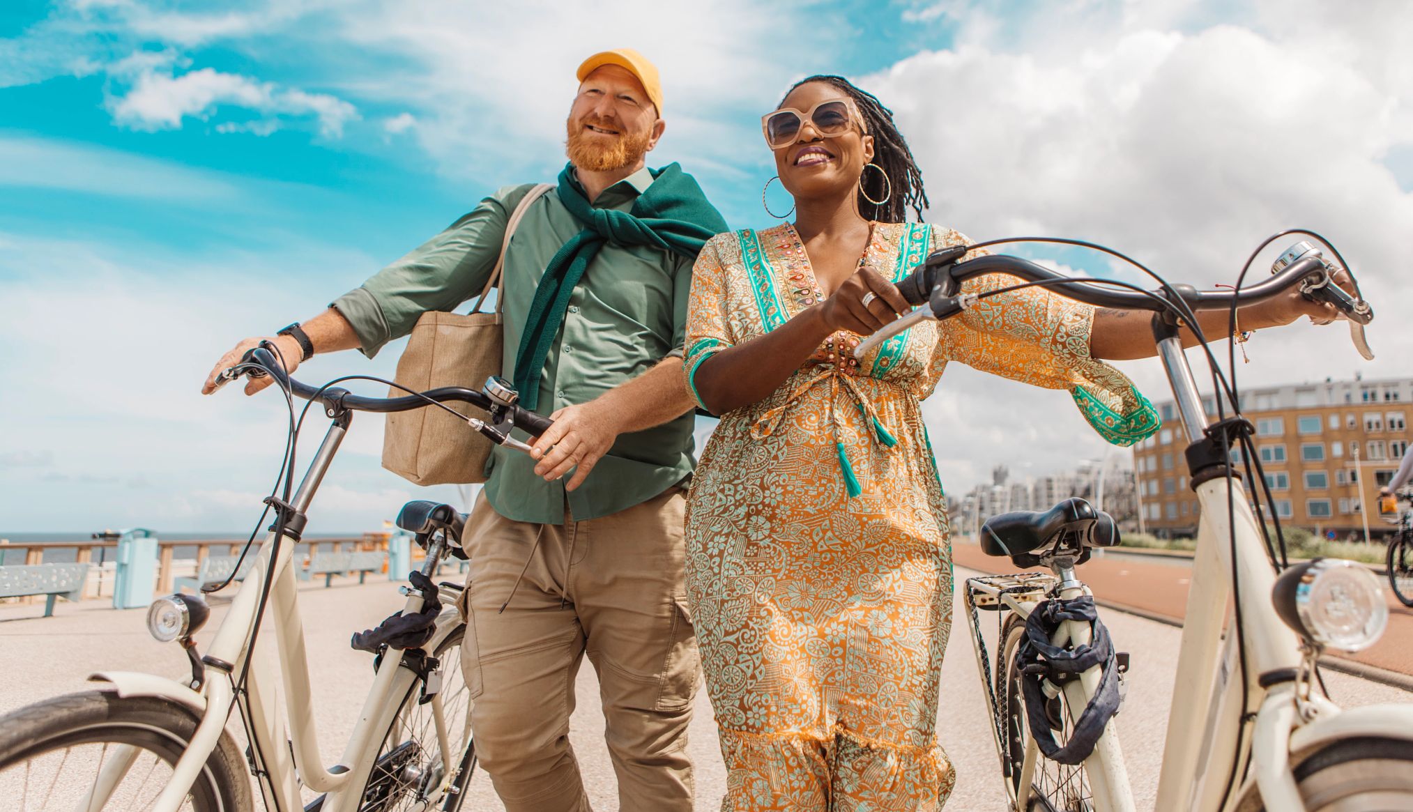 una pareja montando bicicletas a lo largo de una playa