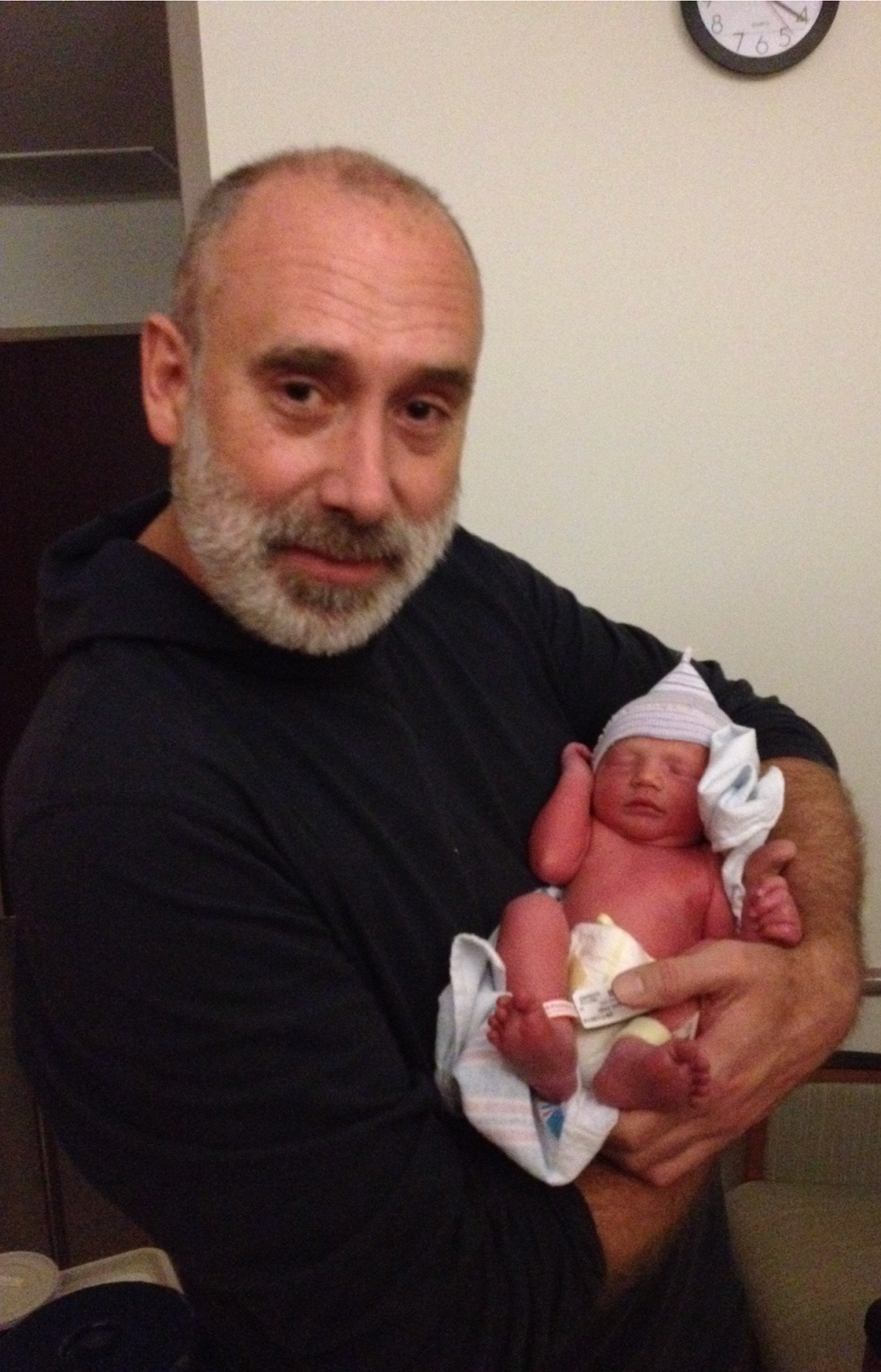 A photo shows author Ted Page with his newborn first grandchild, Henry