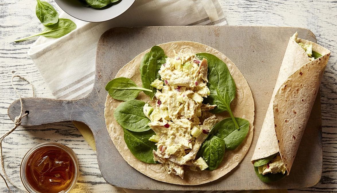 Curried chicken and apple wraps An overhead view of curried chicken and apple wraps on a cutting board