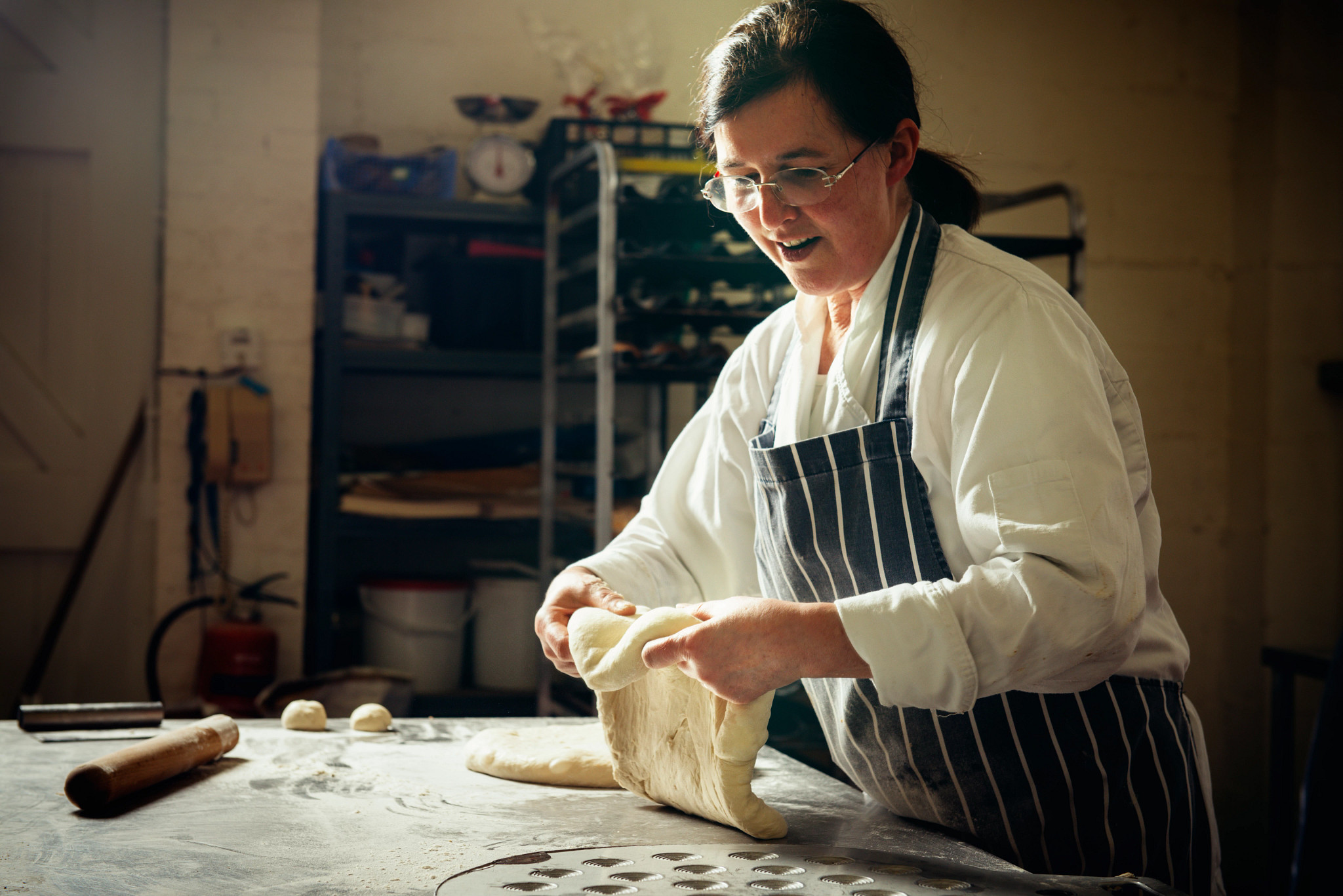 female baker making bread in kitchen