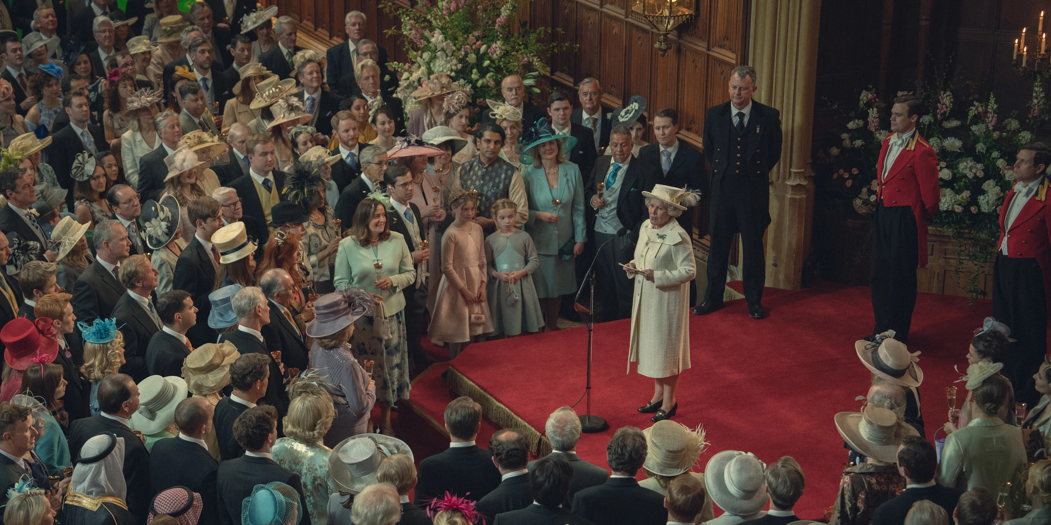 Imelda Staunton standing in front of a microphone making a speech in front of a crown in the Netflix series The Crown