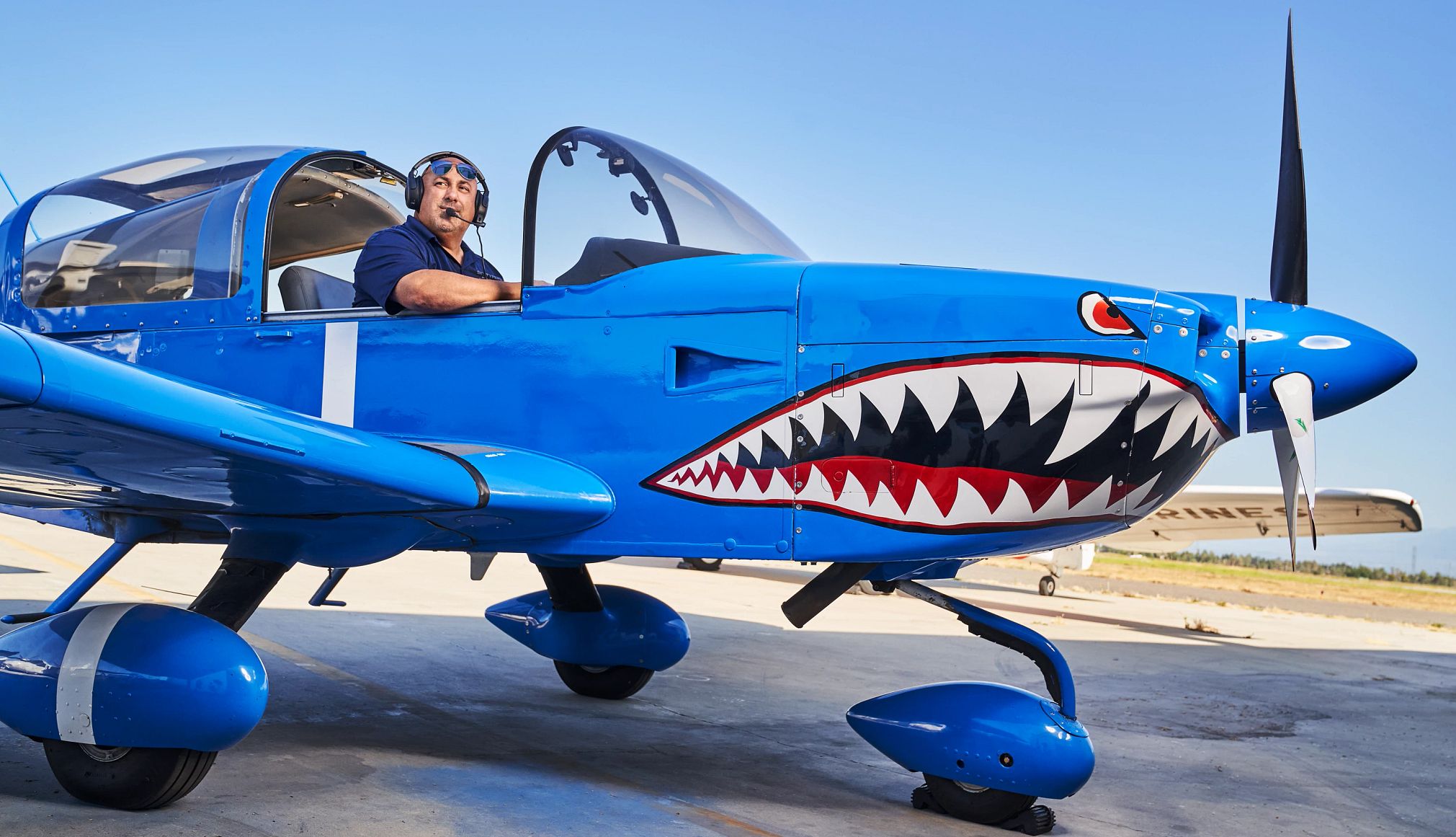 Fastest Skywriter in the World Stephen Stinis, 50, is pictured in a skywriting plane. The plane’s nose is painted like a shark with protruding teeth.