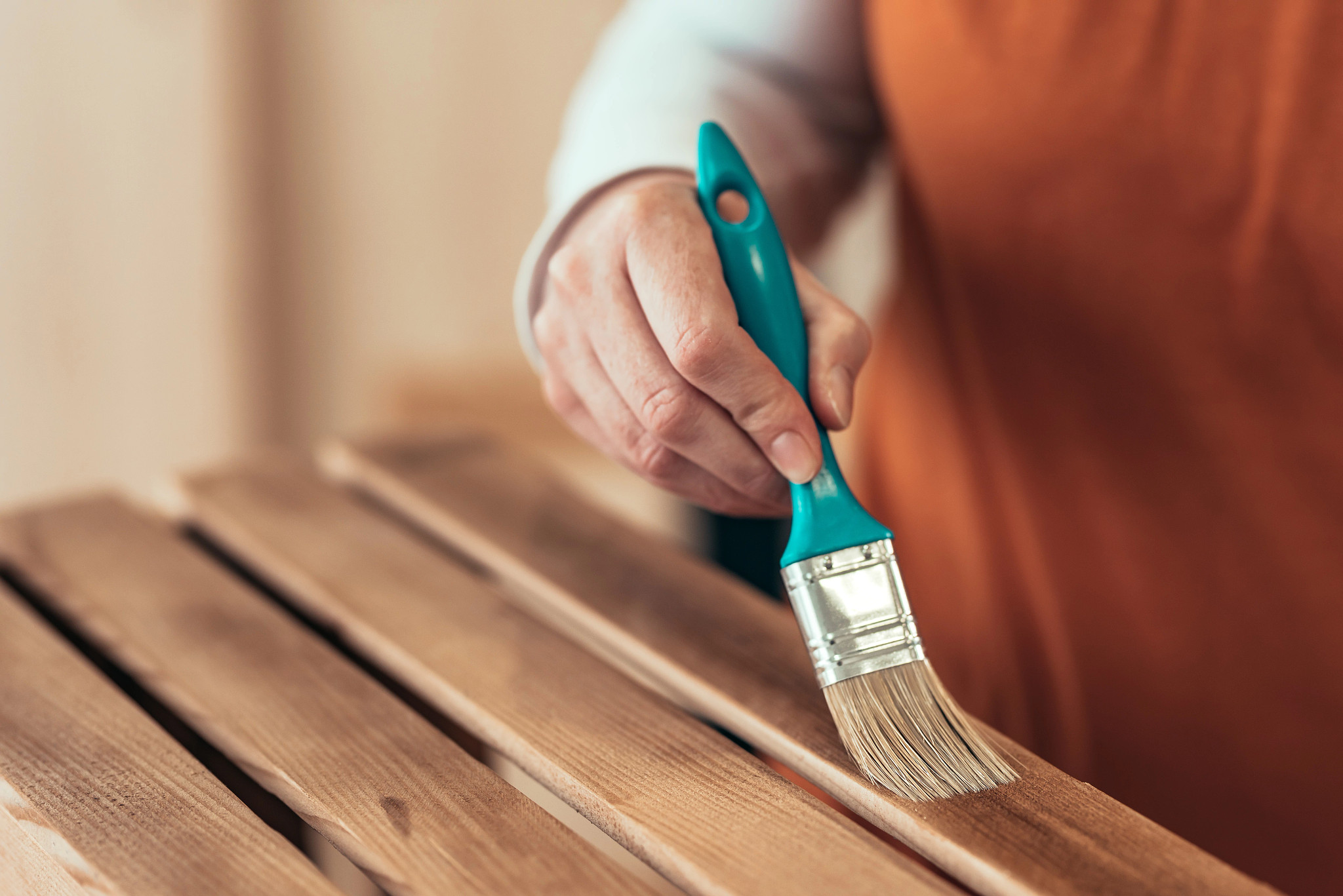Person varnishing wooden crate