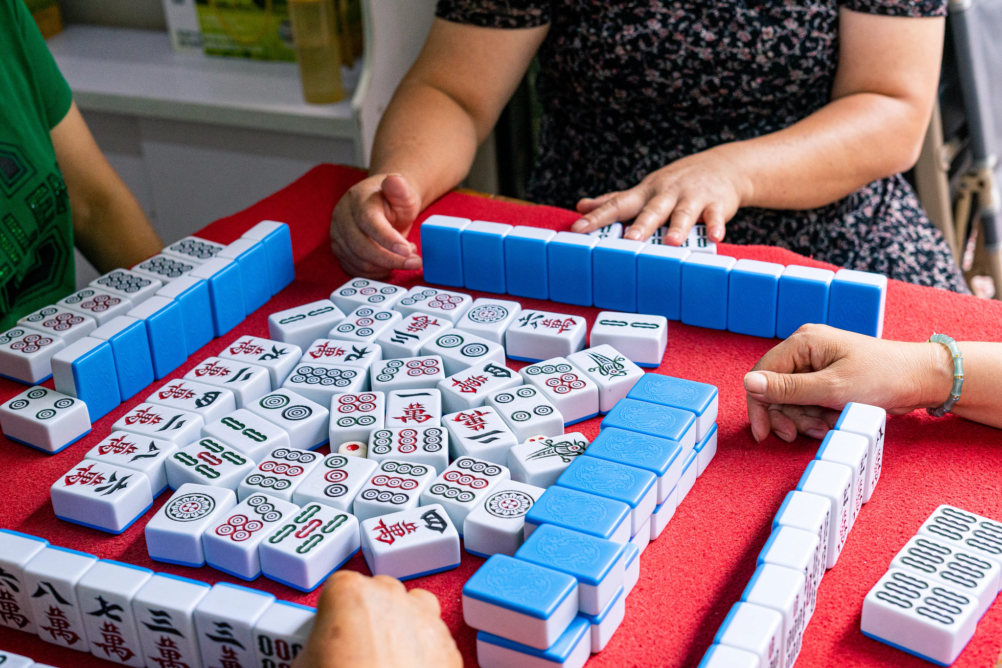 people playing mah-jongg at a table