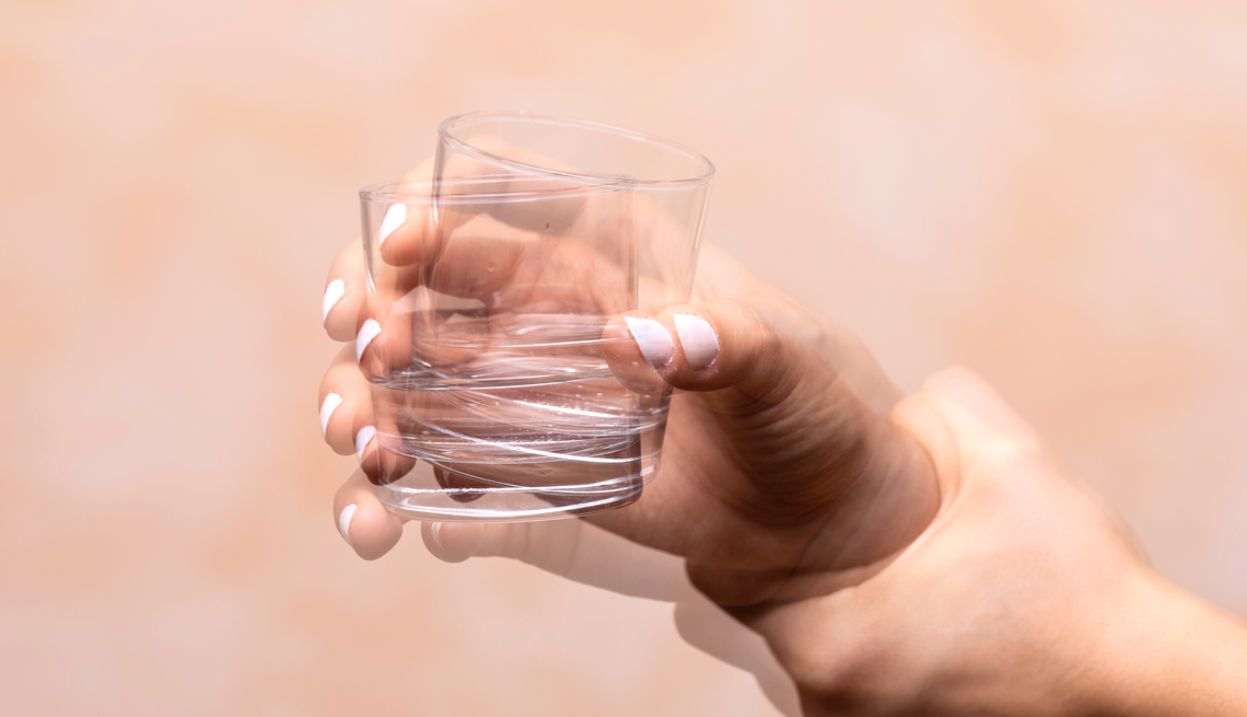 What Is Essential Tremor? shaking hand holding a glass of water