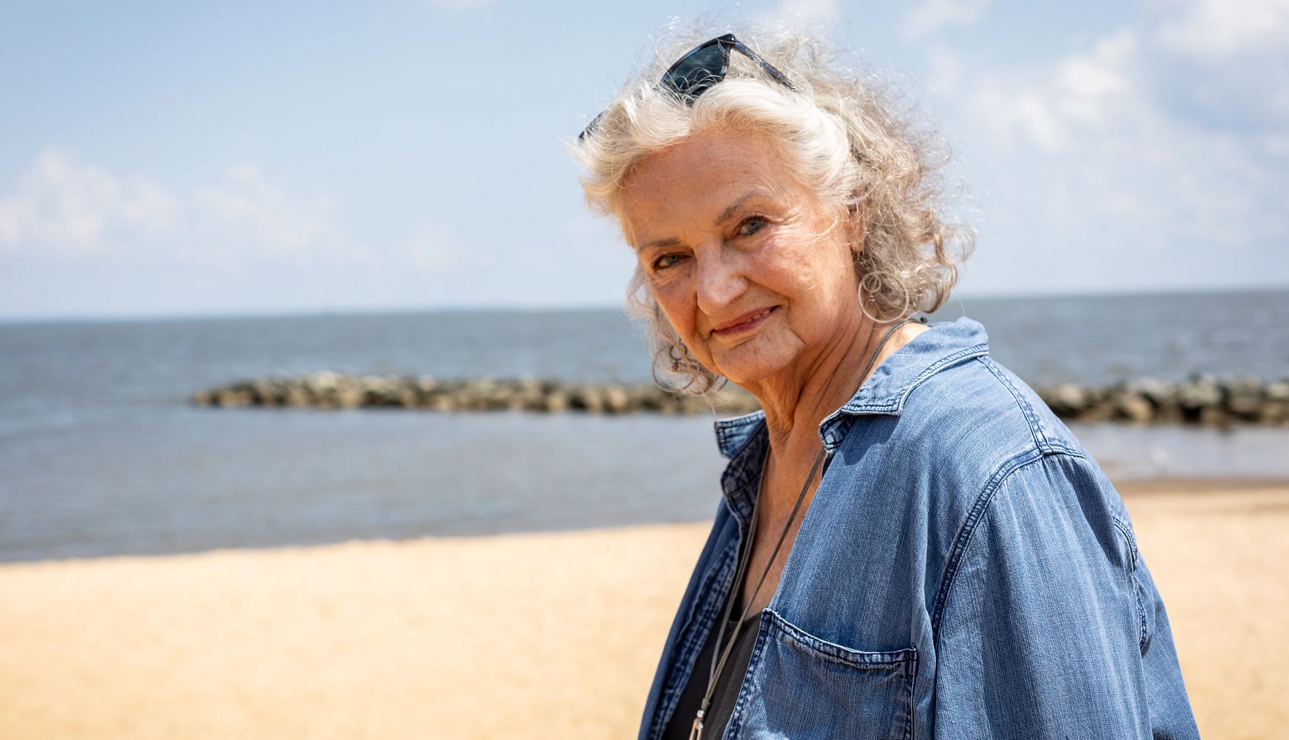 Social Security and Women an older woman standing on a beach