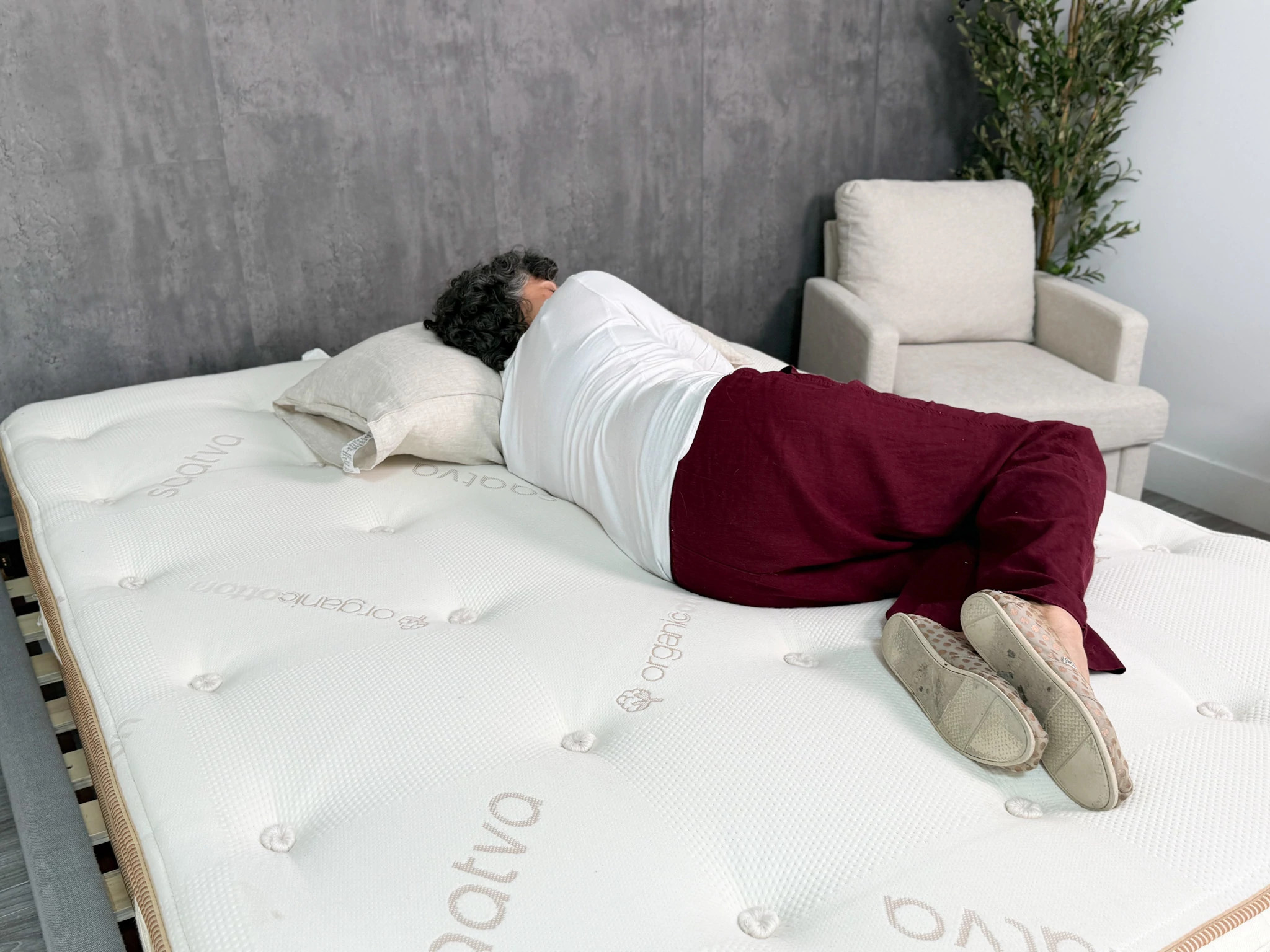 A person lies on their side on the Saatva Latex Hybrid mattress