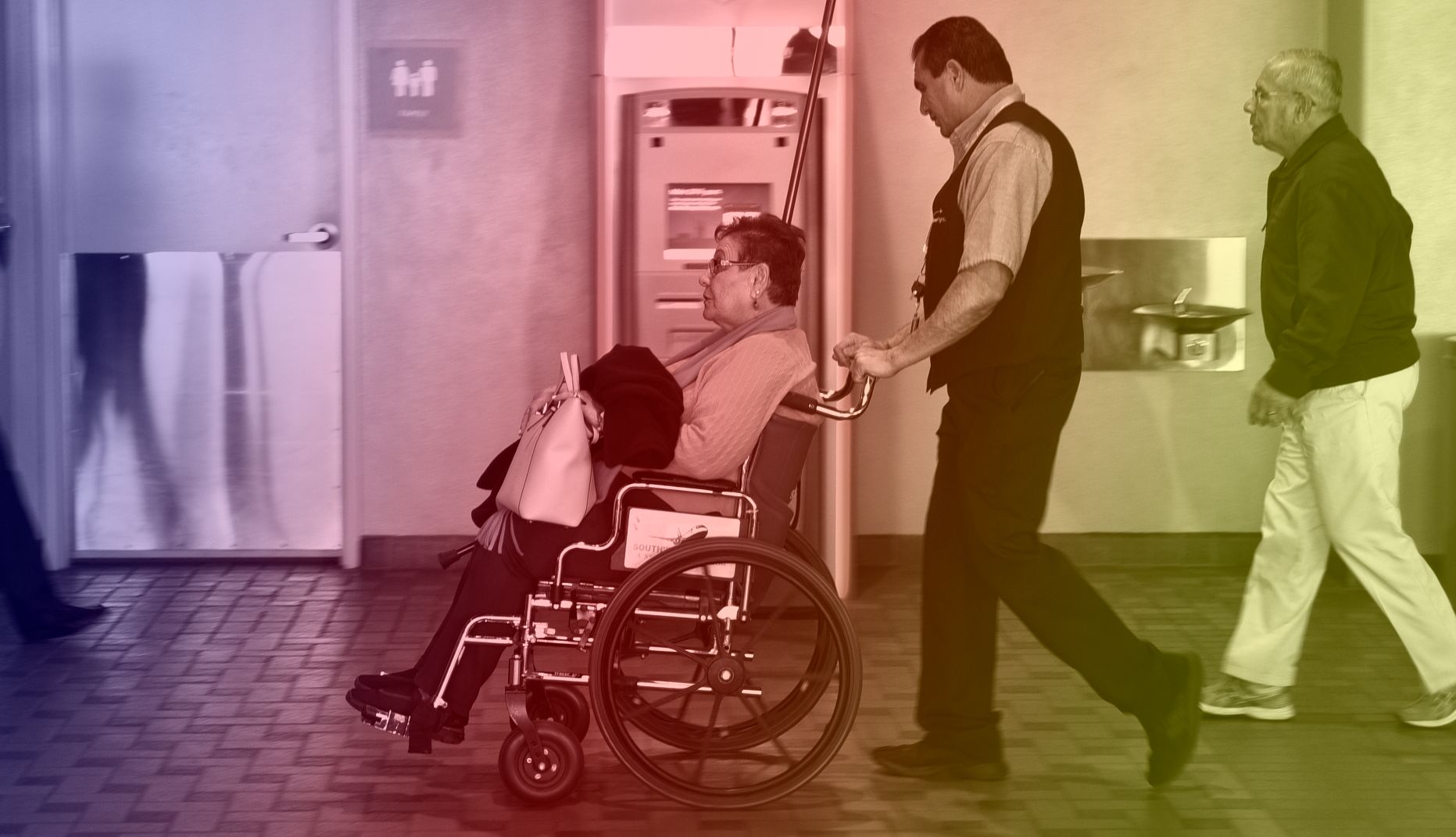 a woman in a wheelchair is being pushed through an airport terminal