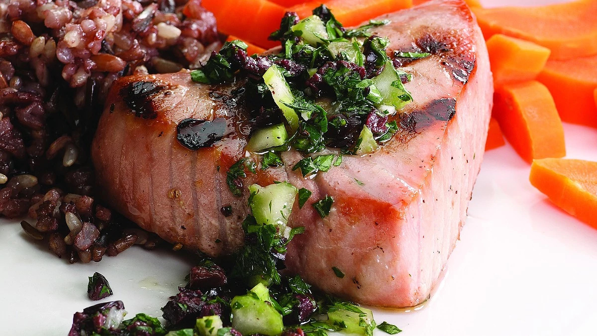 A close-up view of grilled tuna with olive relish
