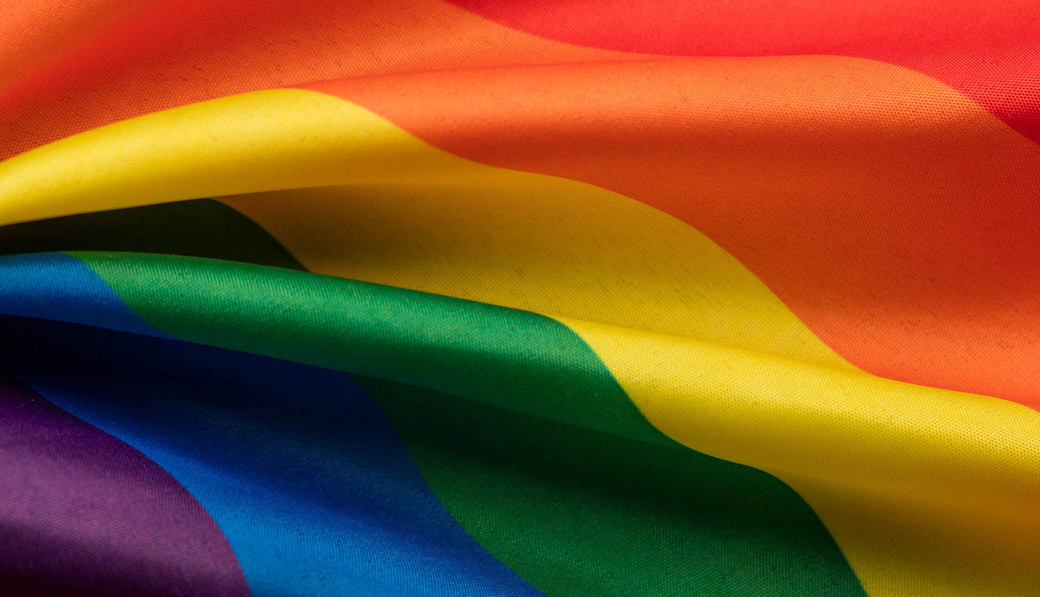 Photo of the LBGTQIA+ flag waving in the breeze Photo of the LBGTQIA+ flag waving in the breeze