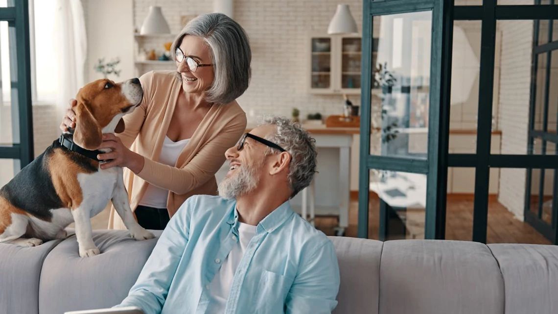 Senior couple playing with their dog.