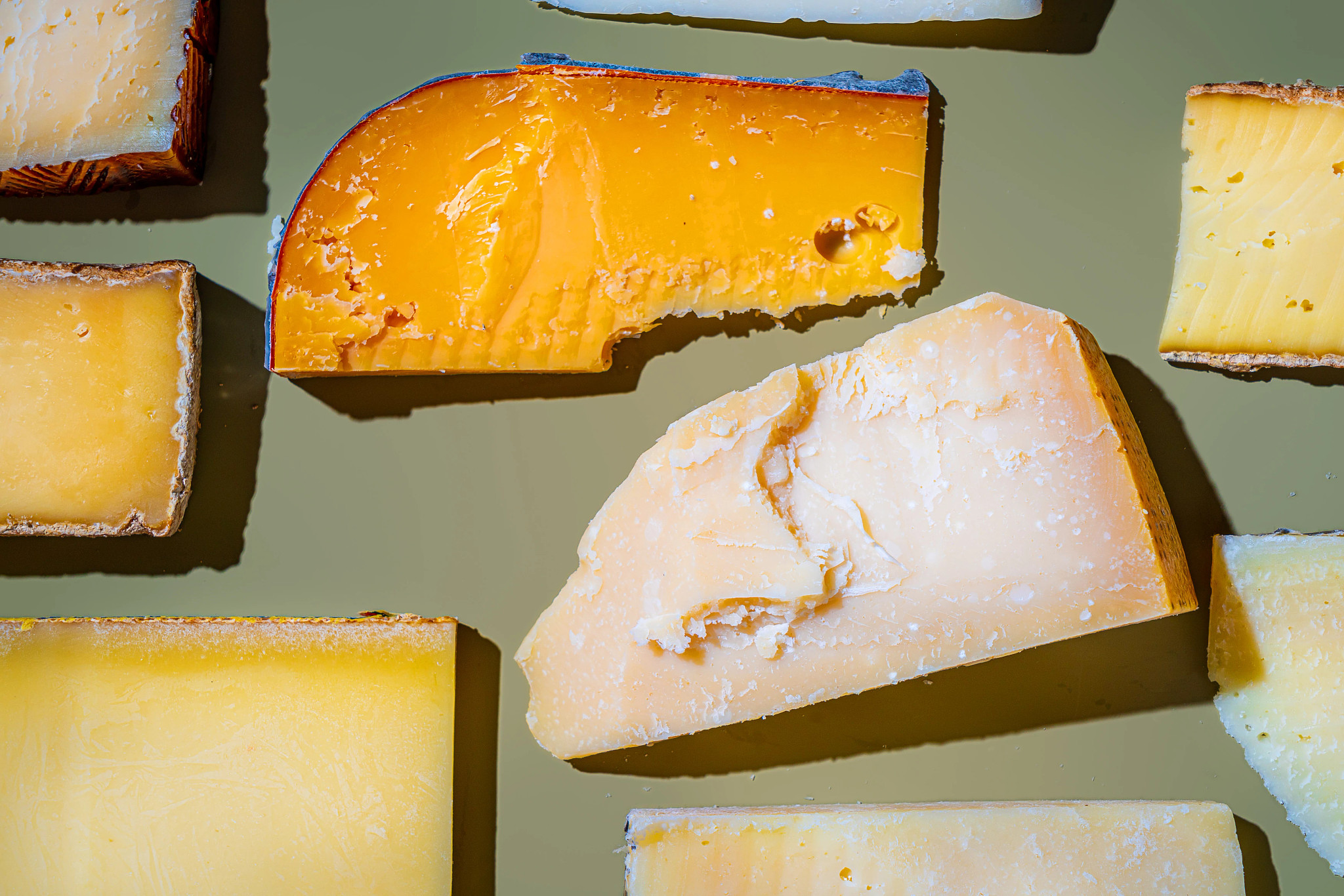 varios quesos duros sobre fondo verde