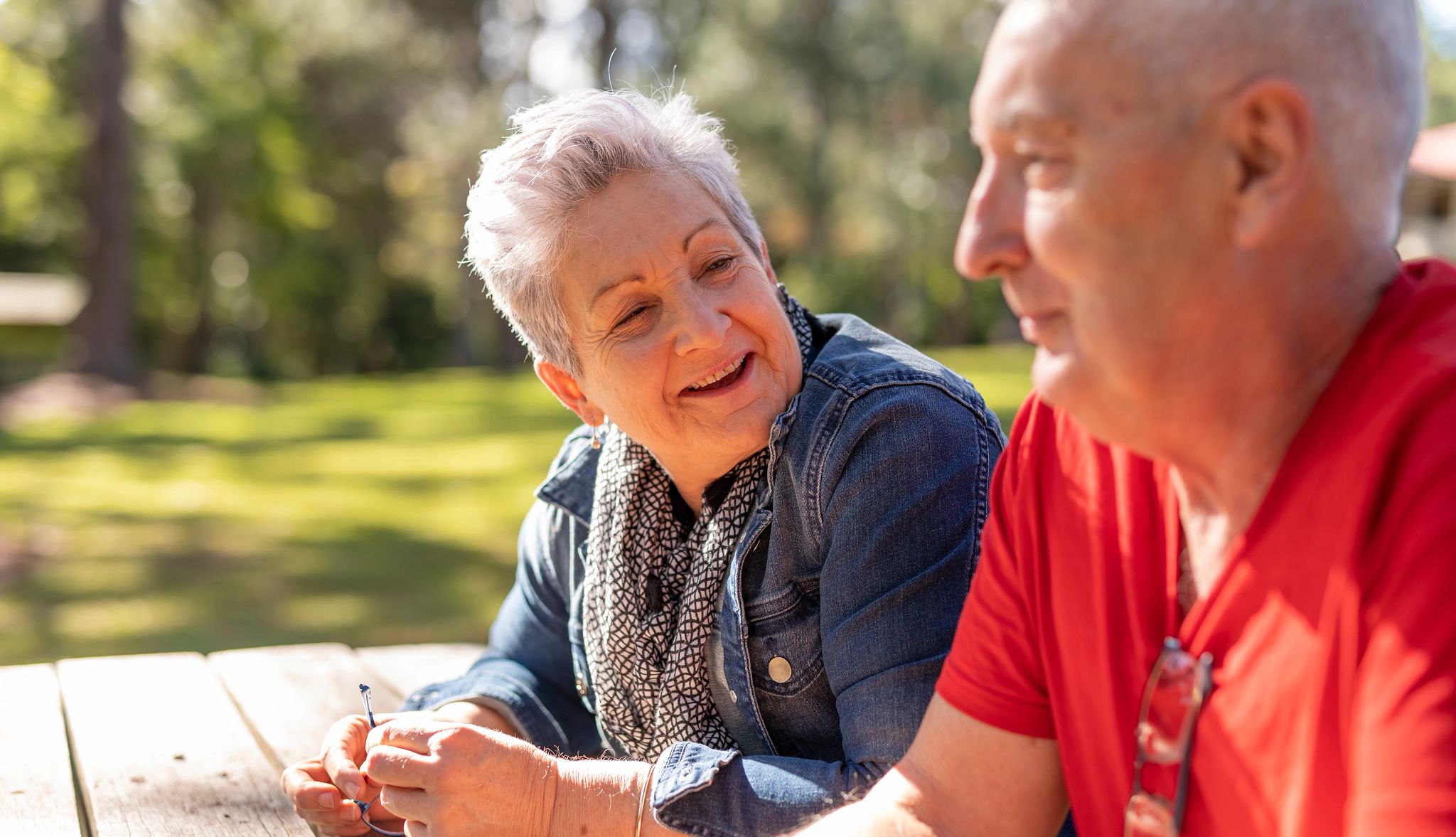 Caregiving conversations can help you plan ahead and give you peace of mind A man and woman sitting at a picnic table in a park