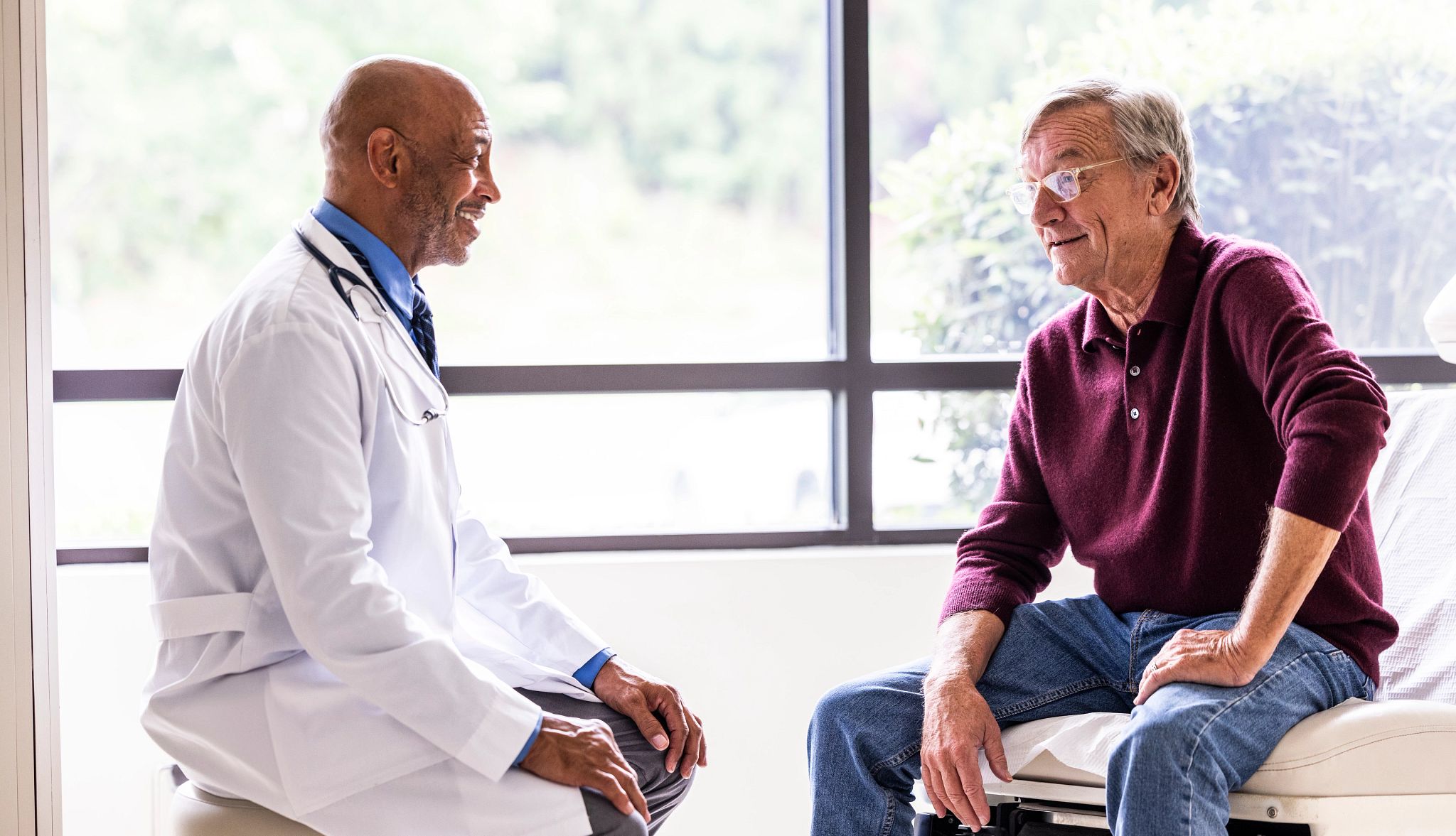 It's helpful to check with a doctor if you're experiencing early warning signs of Parkinson's disease A male doctor talking with a male patient in an exam room