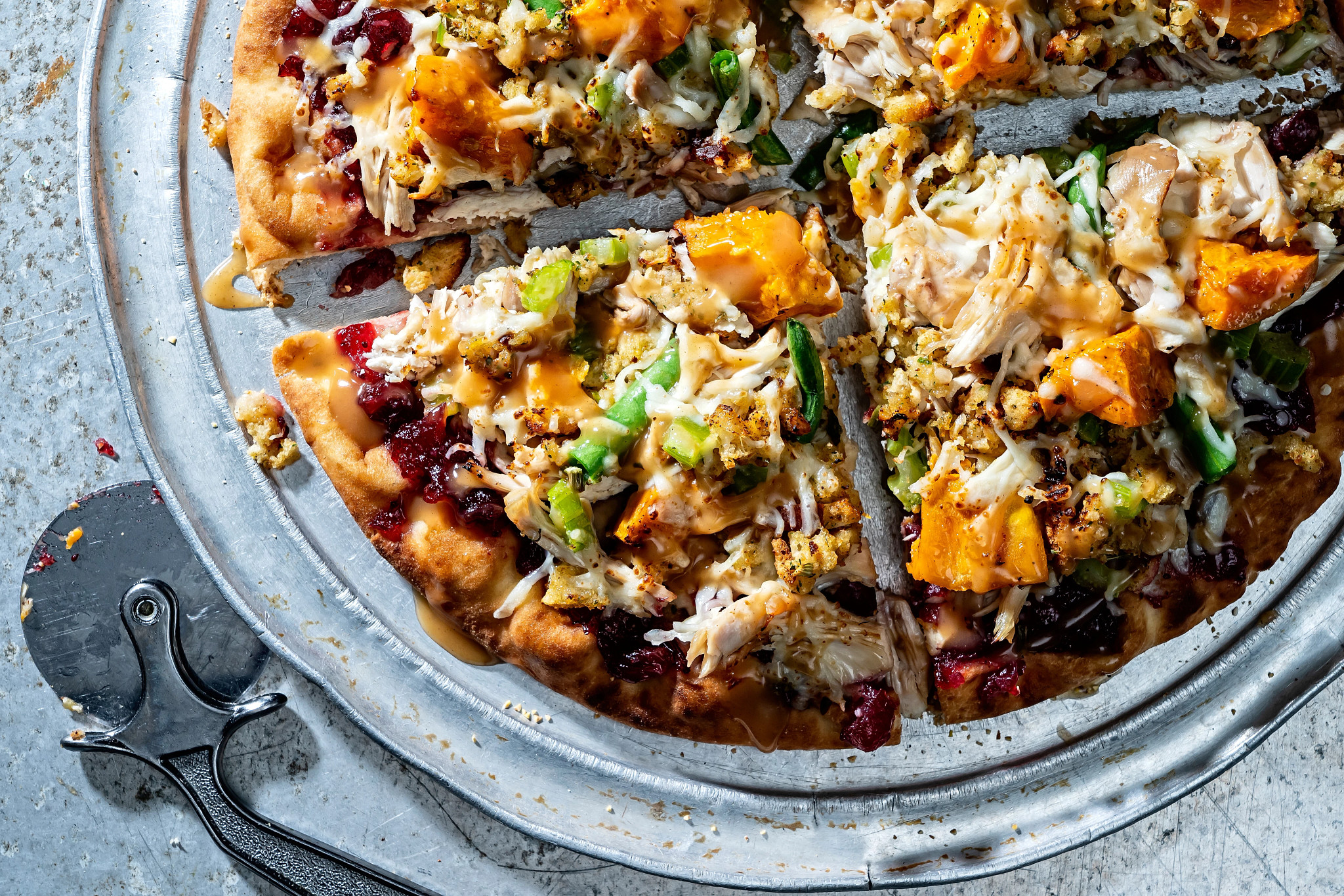a photo shows leftover turkey pizza on a metal pan