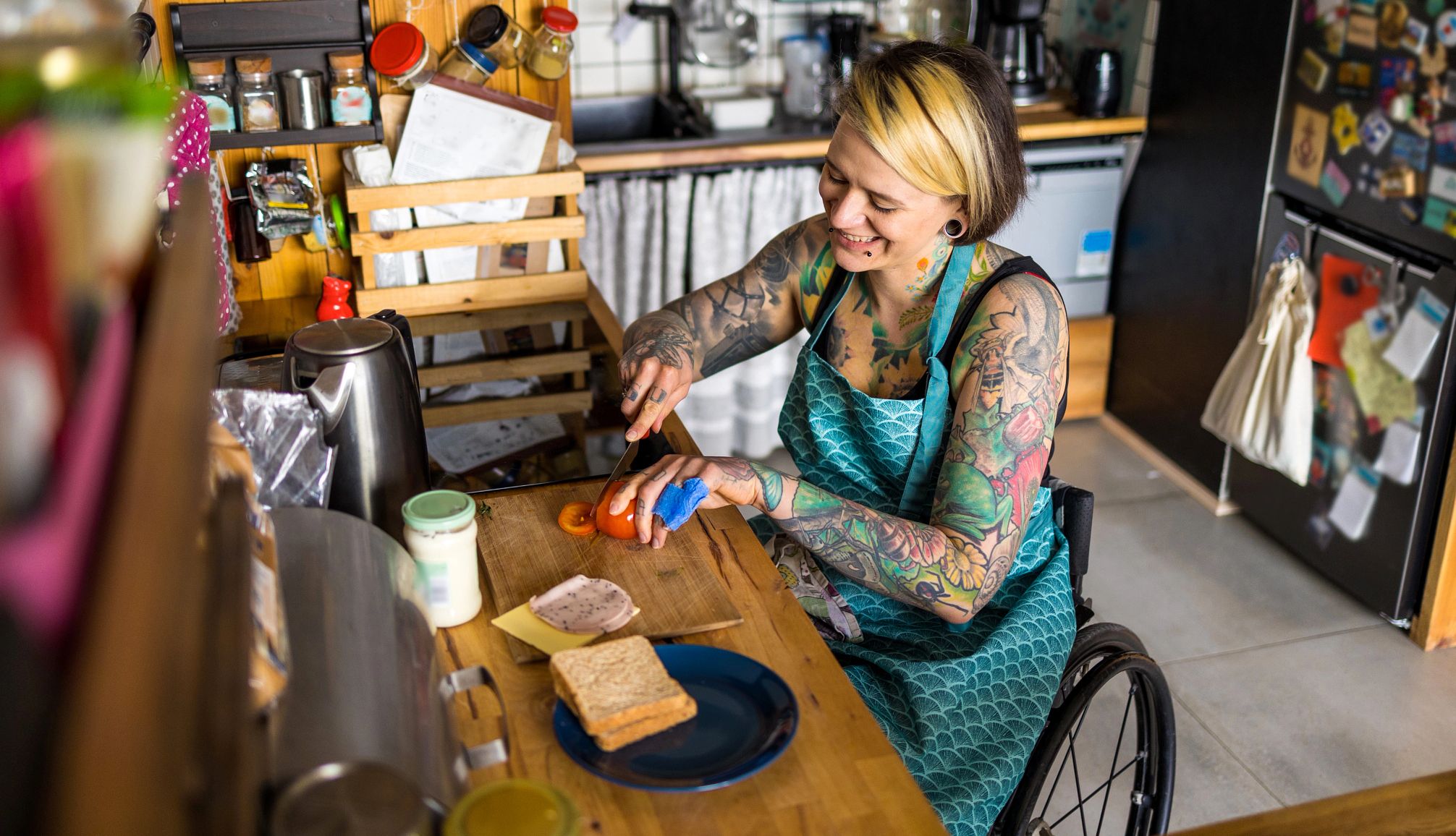 a woman in a wheelchair prepares food in a kitchen