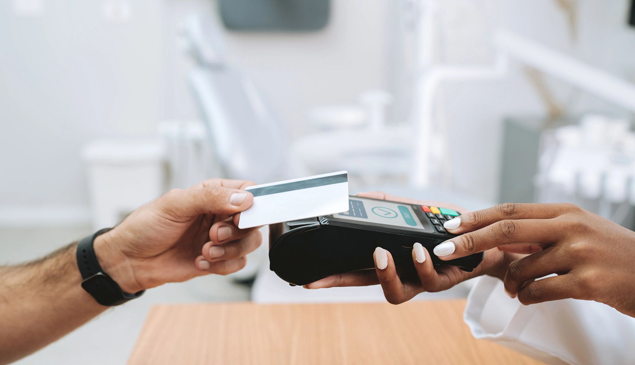 Smart Guide to Oral Health someone tapping a card to pay
