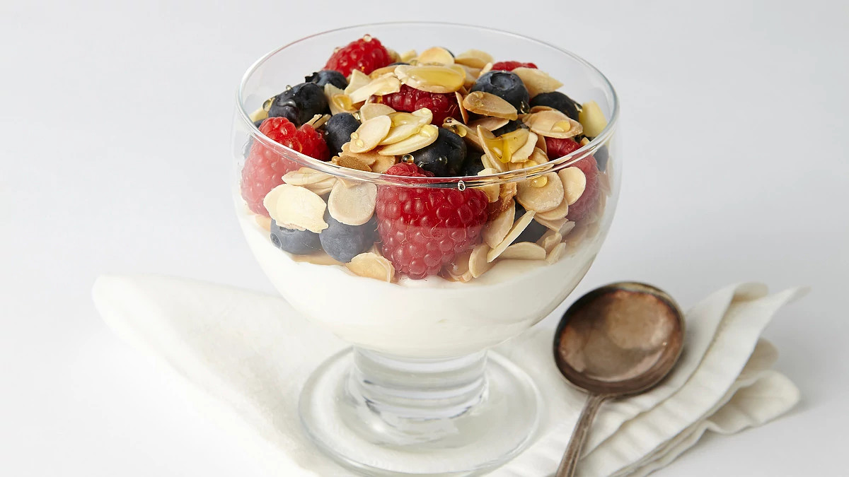 A close-up view of nut and berry parfait in a bowl