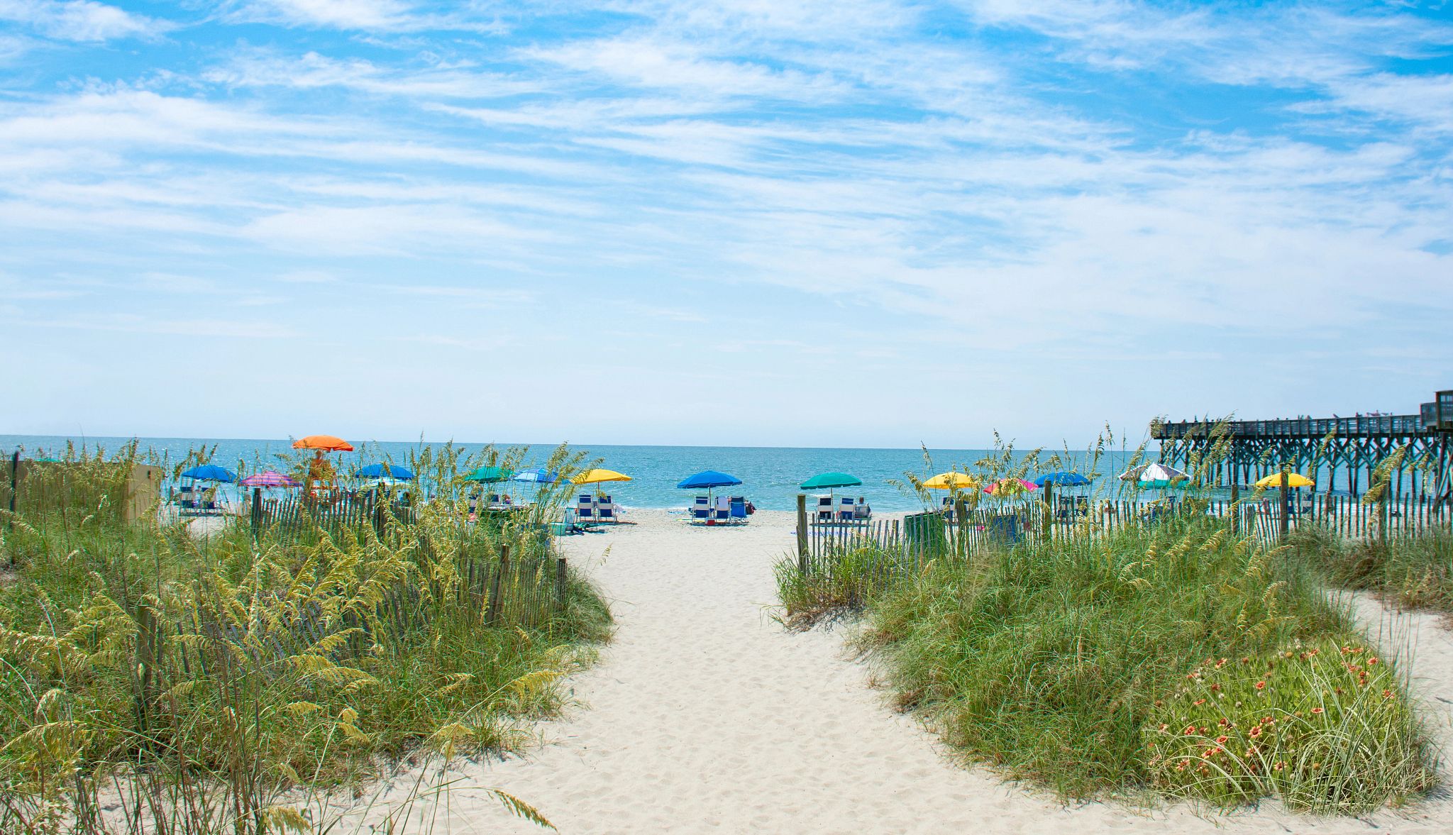 Beach Towns for Fall Getaways umbrellas and chairs set up on a beach