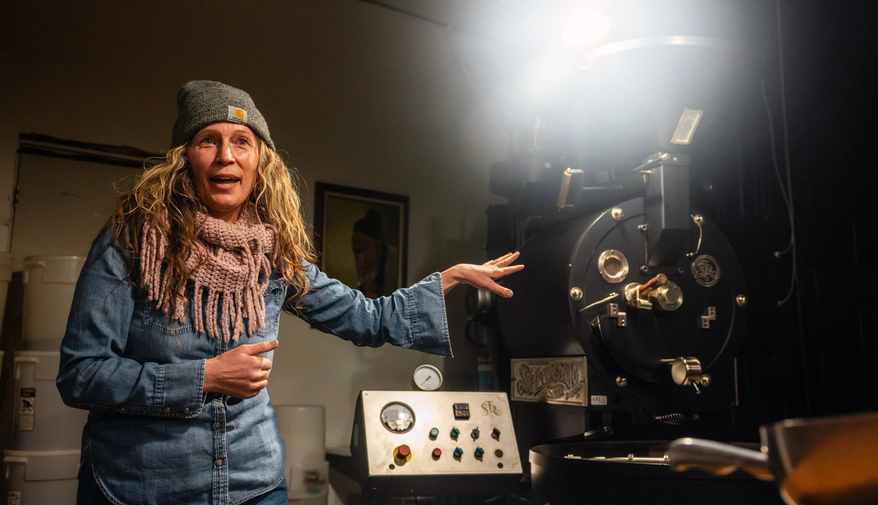 a woman pointing at equipment while giving a factory tour
