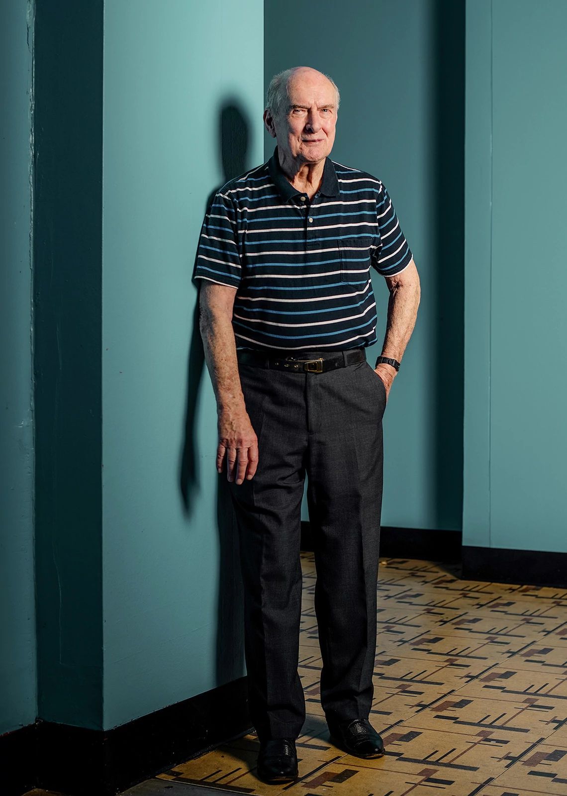 David Smith david smith poses in a dark striped shirt and dark pants