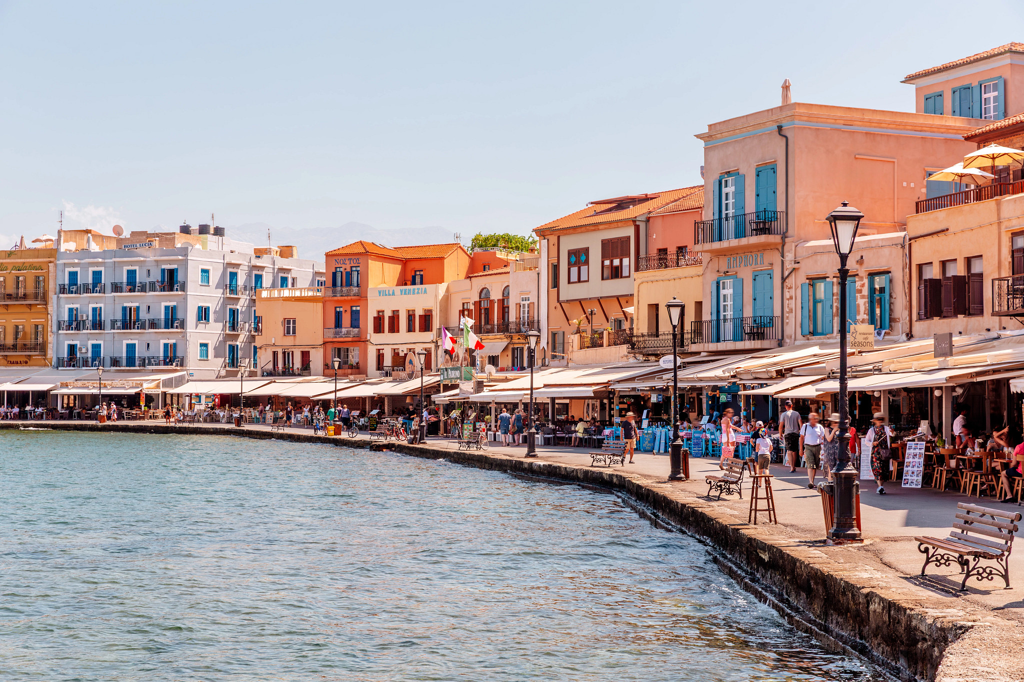 Promenade along a harbor with bright colorful houses on a sunny day