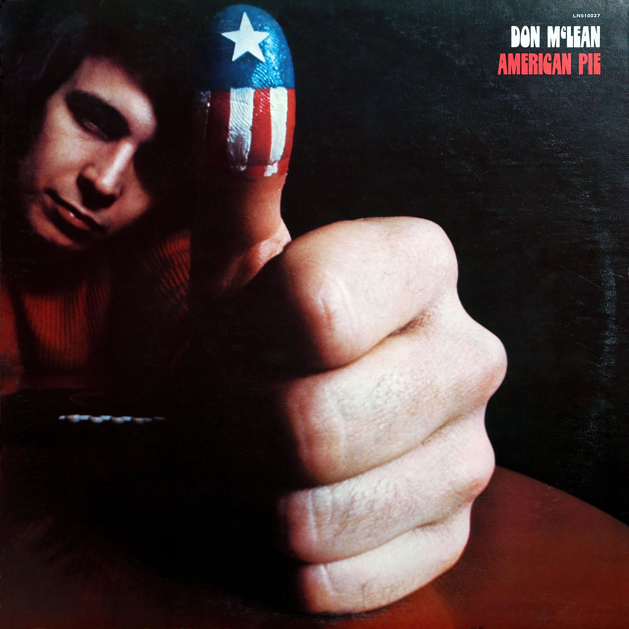 Don McLean on “American Pie” a man gives a thumbs up on the album cover of american pie. the thumb is painted red, white and blue to resemble an american flag.