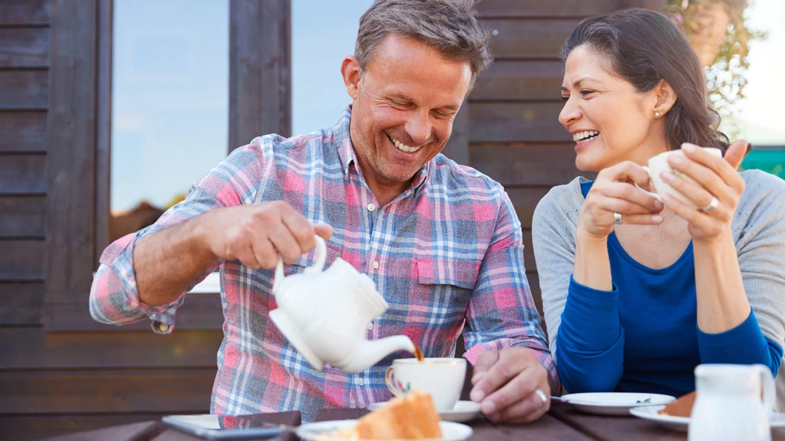 Portrait Of Mature Couple Sitting On Bench In Cafe Whilst Visiting Garden Center