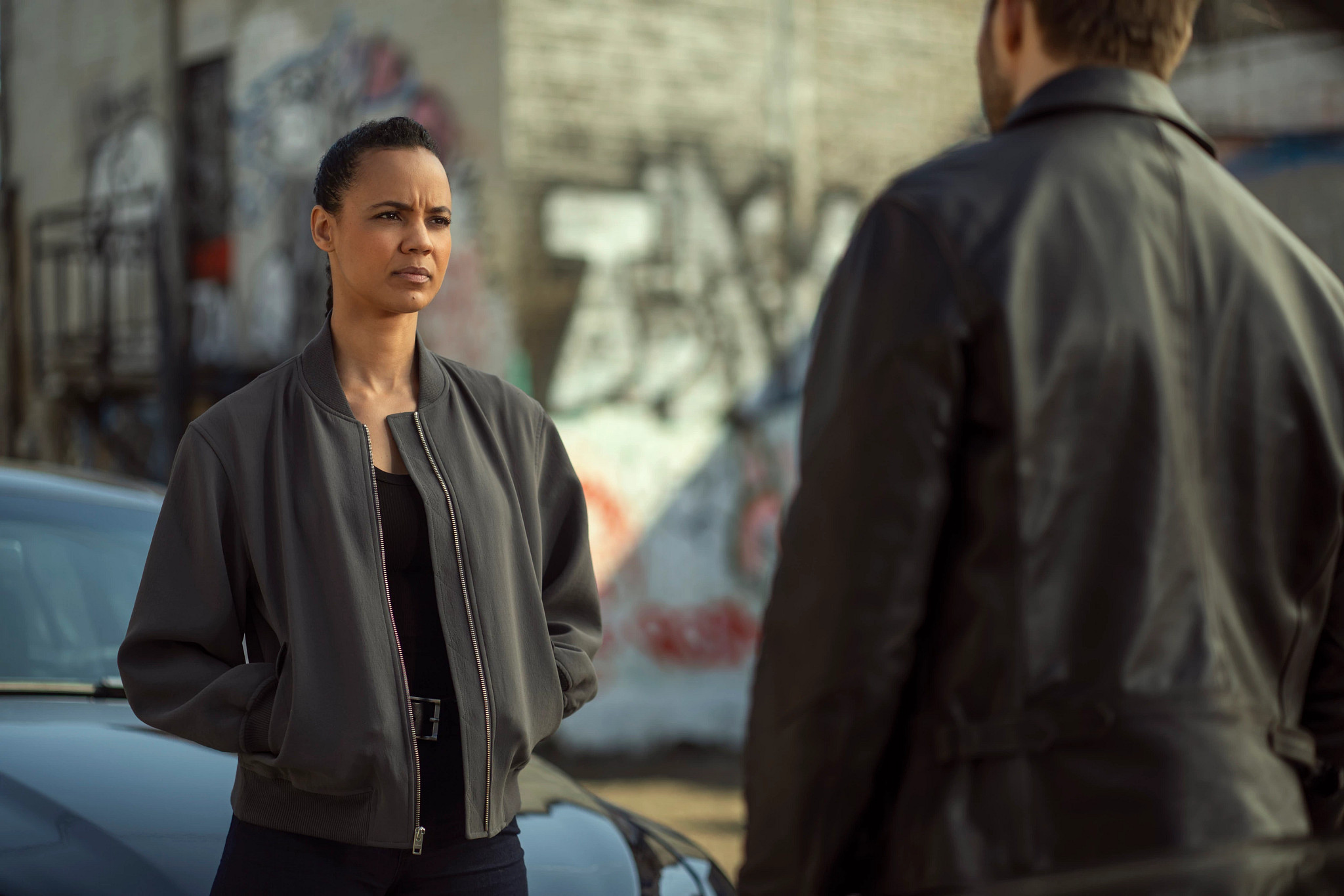 Maria Sten standing engages in a conversation with Greyston Holt in television show, "Neagley."