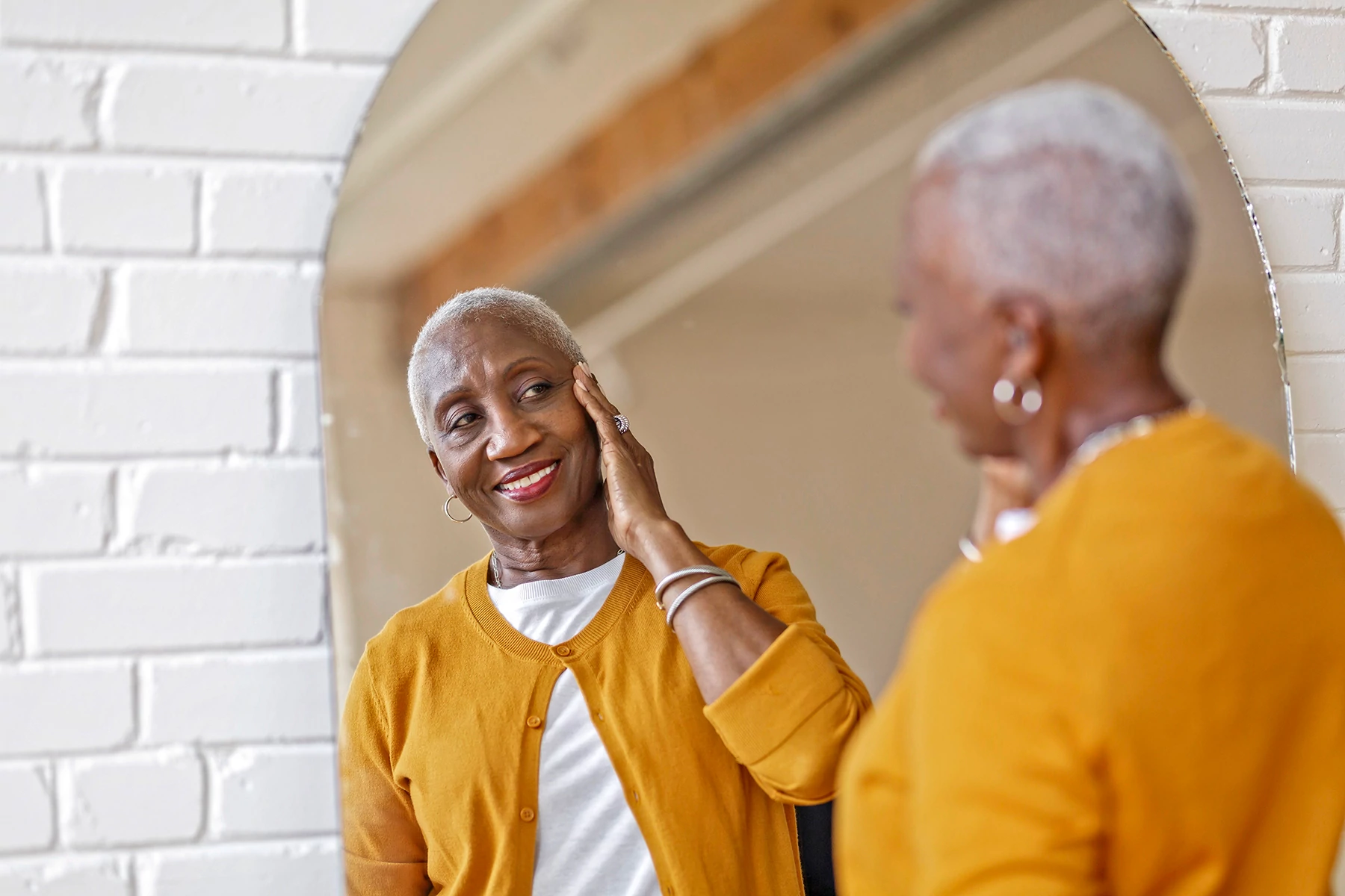 photo of woman looking at herself in mirror