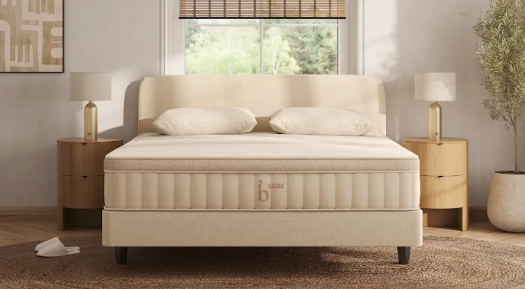 The Birch Luxe Natural mattress in a sunny bedroom with two nightstands on either side.