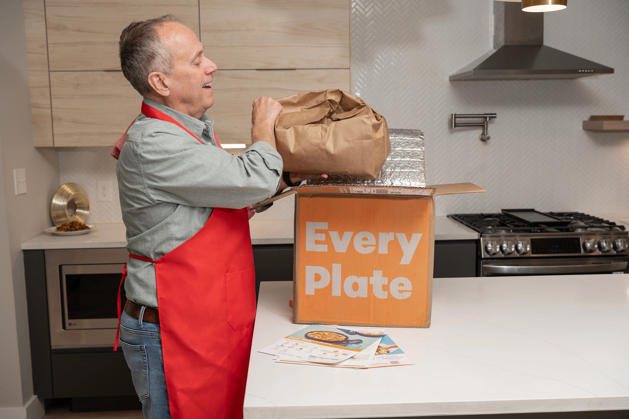An older man unpacking his EveryPlate meal kit box.