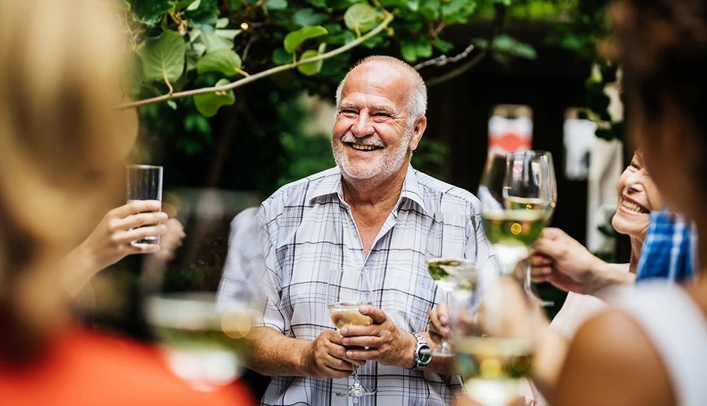 Having a regular gathering is important for maintaining good health A man making a toast at an outdoor social gathering