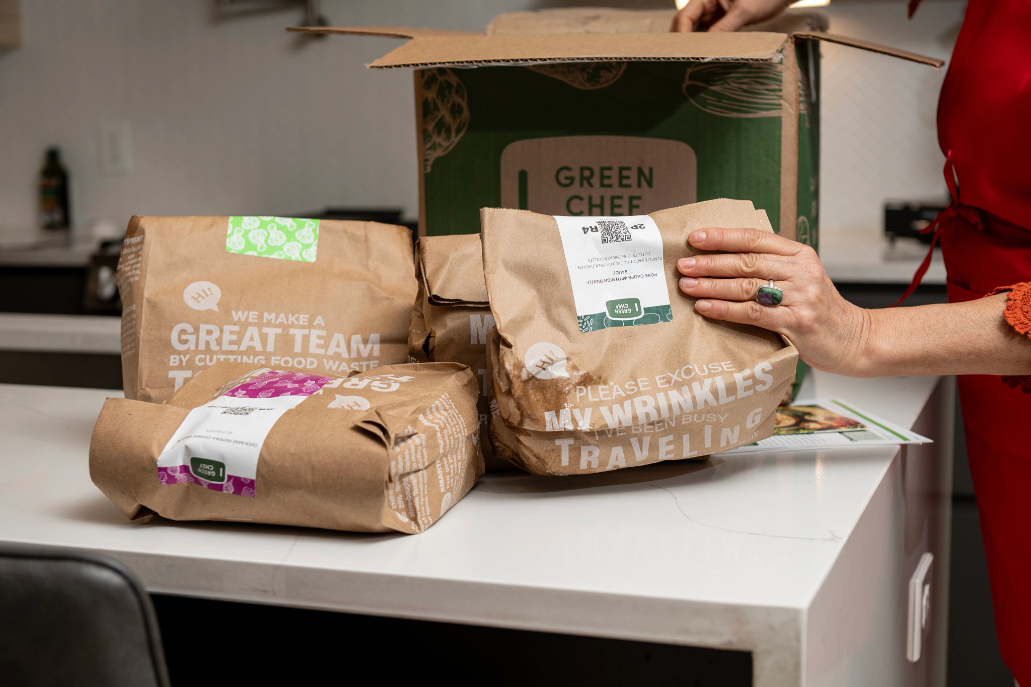 Older adult woman unpacking her Green Chef meal kit package.