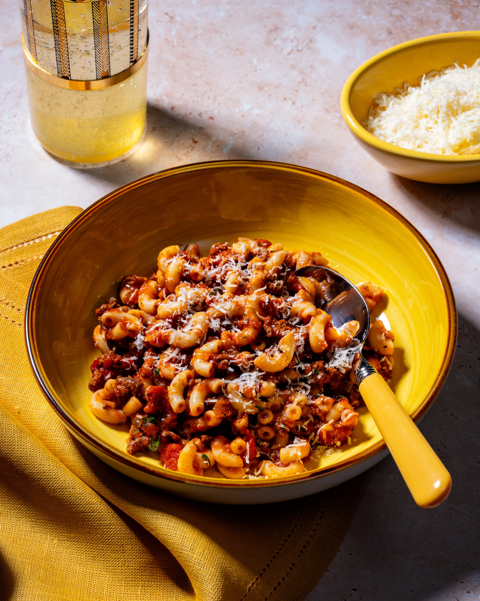 View of Slow Cooker Goulash in a yellow bowl with yellow tile background