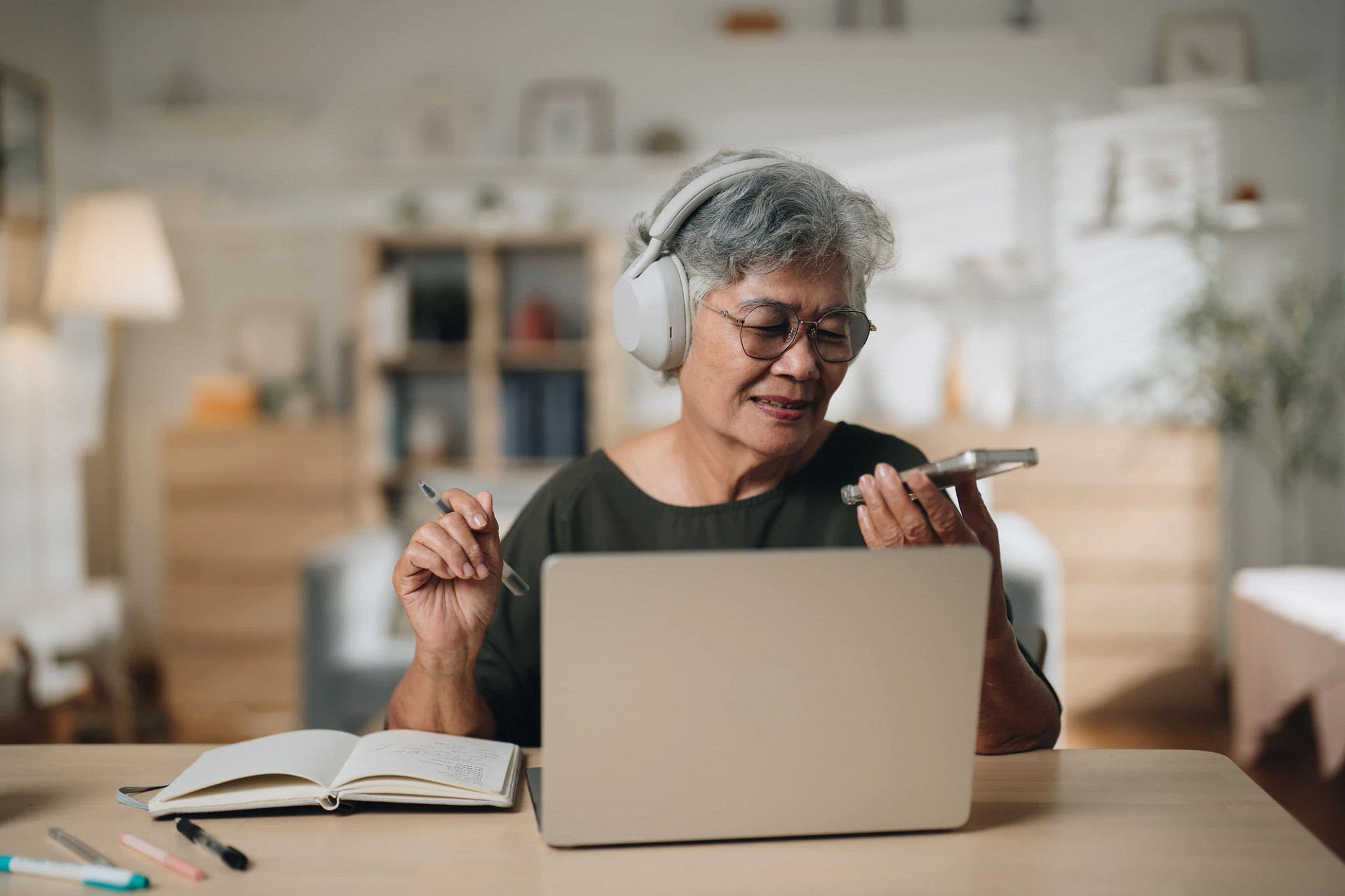Senior woman using an AI-powered app on her smartphone to enhance her online language lesson.