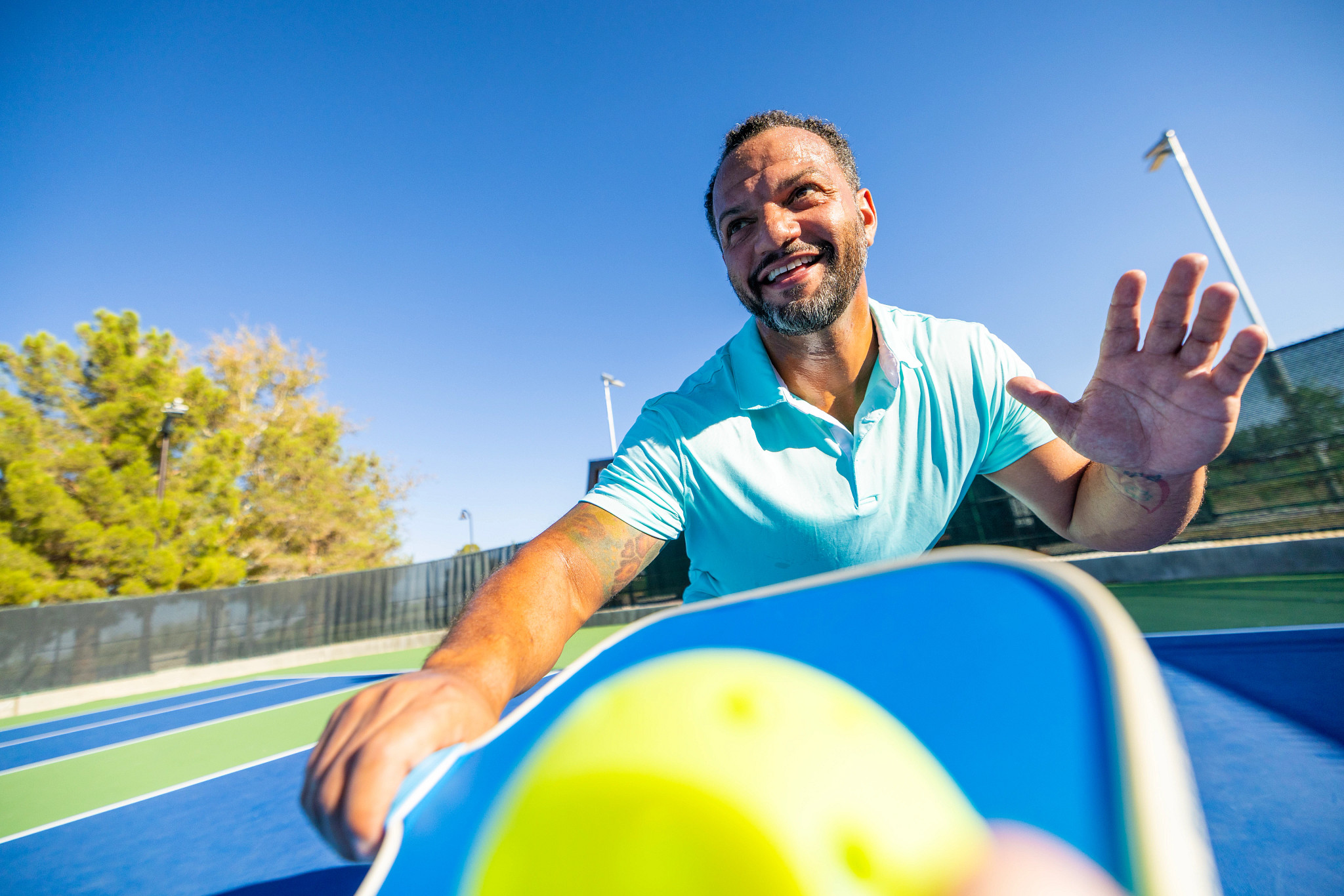 A man playing pickleball at the park.