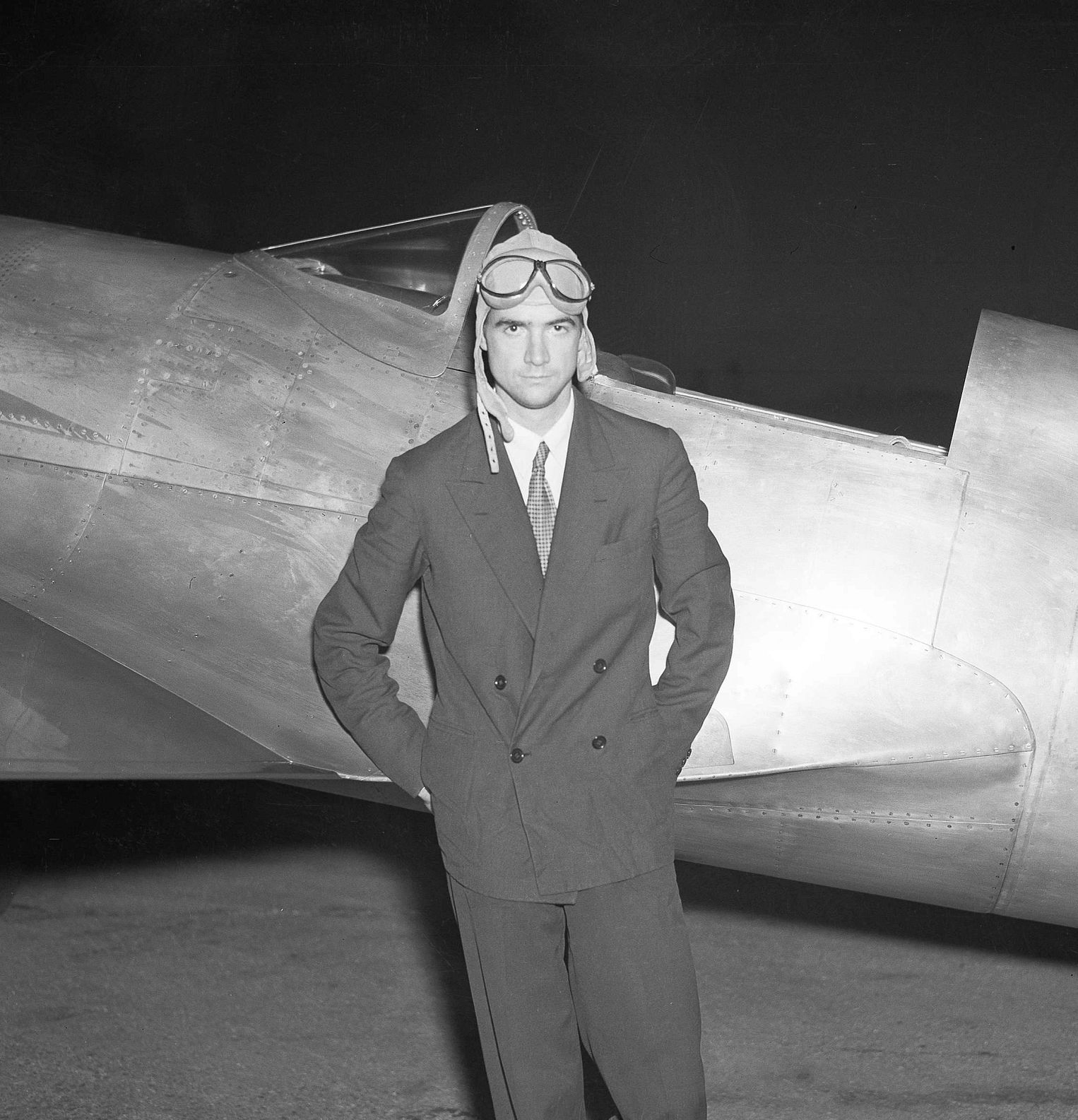 Howard Hughes Howard Hughes standing next to a plane