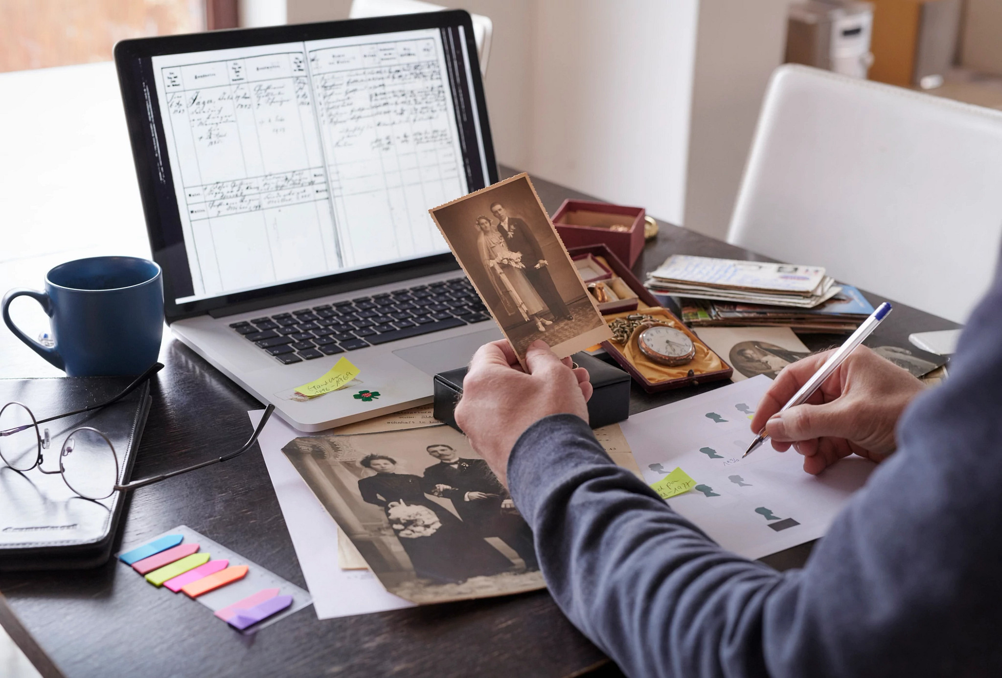 Man sitting on table doing research on family members on computer for family tree.