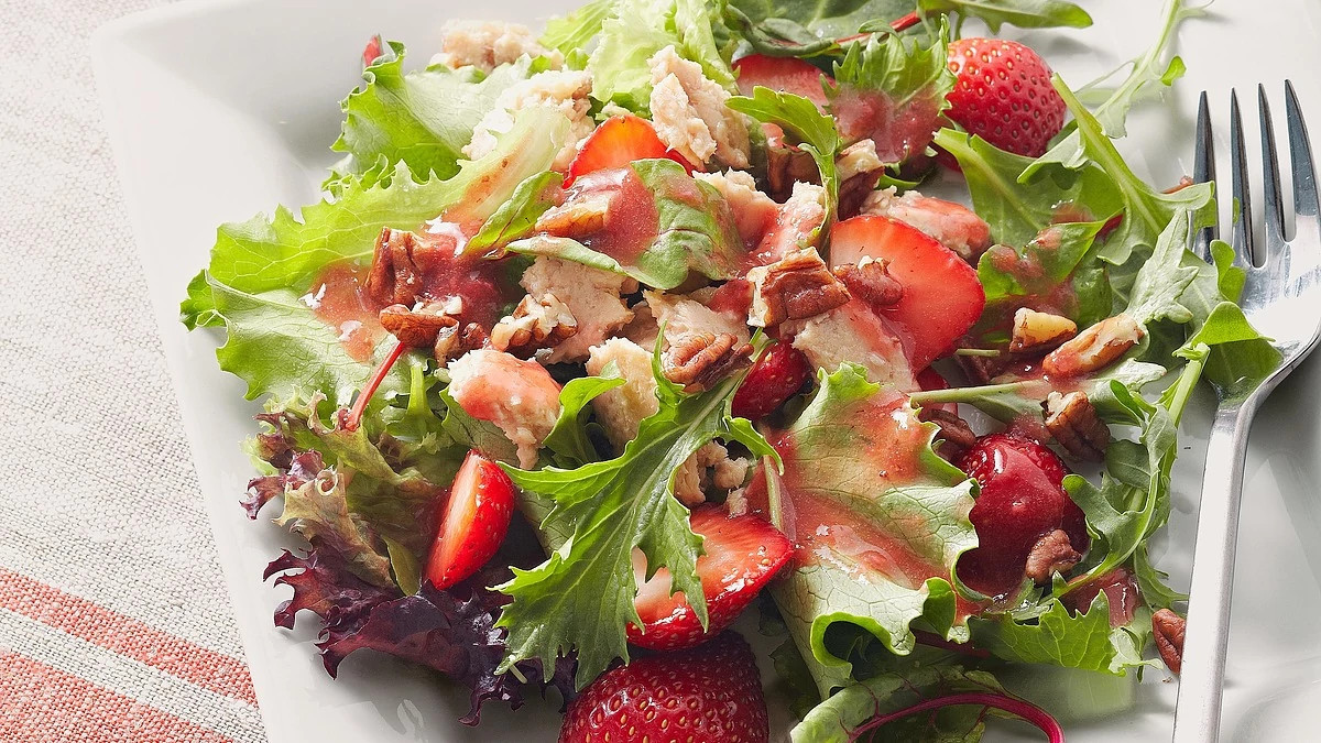 A close-up view of salmon salad with strawberry vinaigrette on a plate