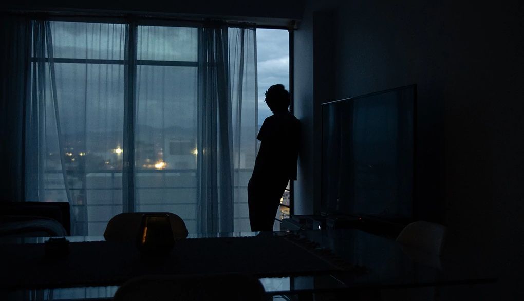 Try getting out of bed when you can’t sleep A silhouette of a man standing in the dark by a window at home