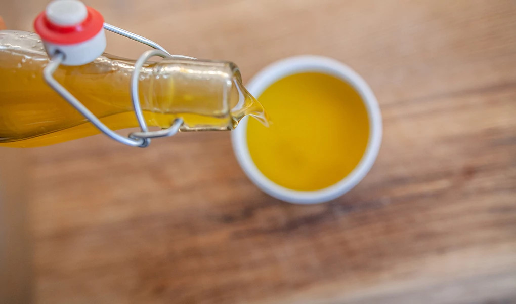 A close-up view of olive oil being poured into a small bowl